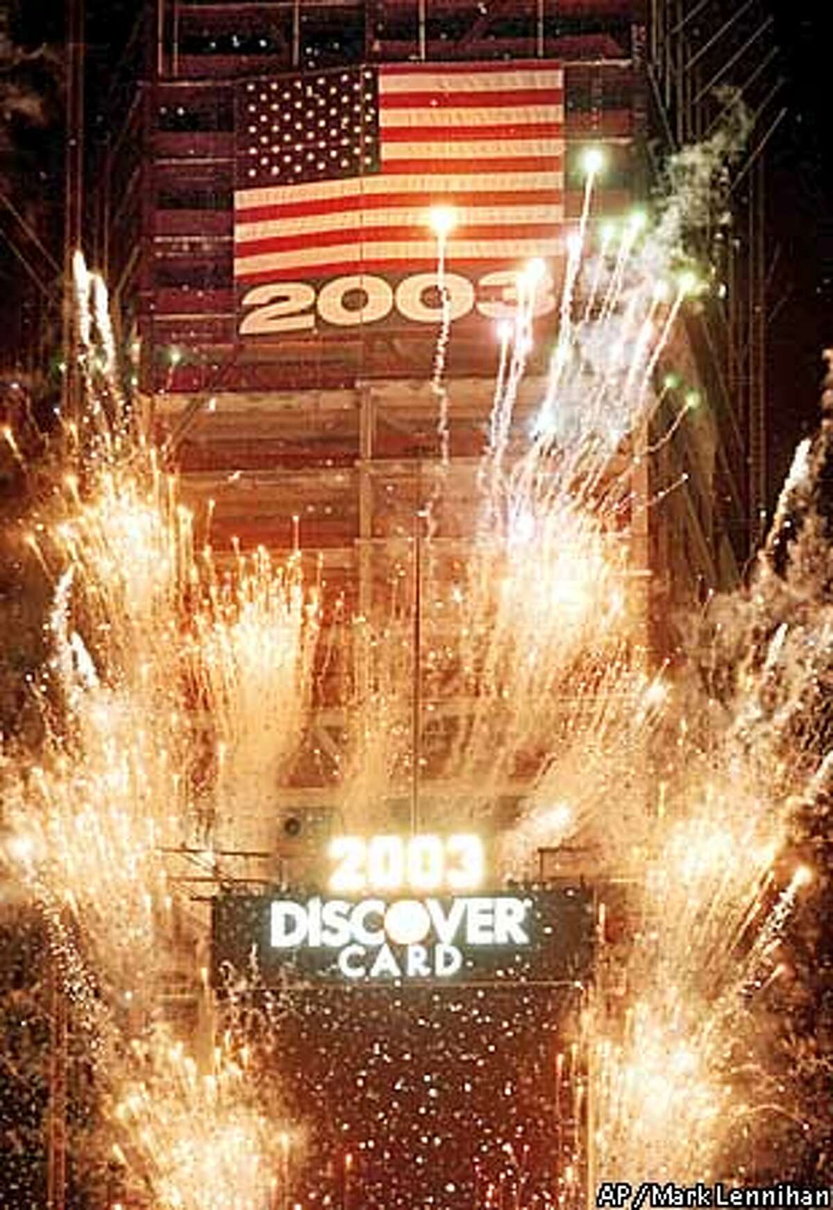 Fireworks light New York's Times Square moments after the New Year begins Wednesday, Jan. 1, 2003. An American flag is draped from a building under construction behind the ball drop at 1 Times Square. (AP Photo/Mark Lennihan)