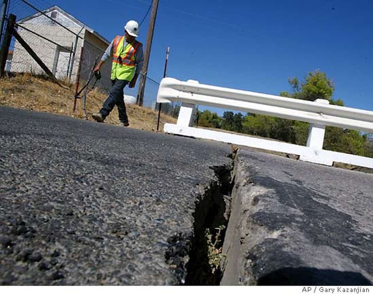 Ramon Martinez of Monterey Co. Public Works checks a crack in a bridge from an earthquake Tuesday, Sep. 28, 2004 in Parkfield, Calif. The bridge suffered some strutural damage including separating nearly six inches from the road. (AP Photo/Gary Kazanjian)