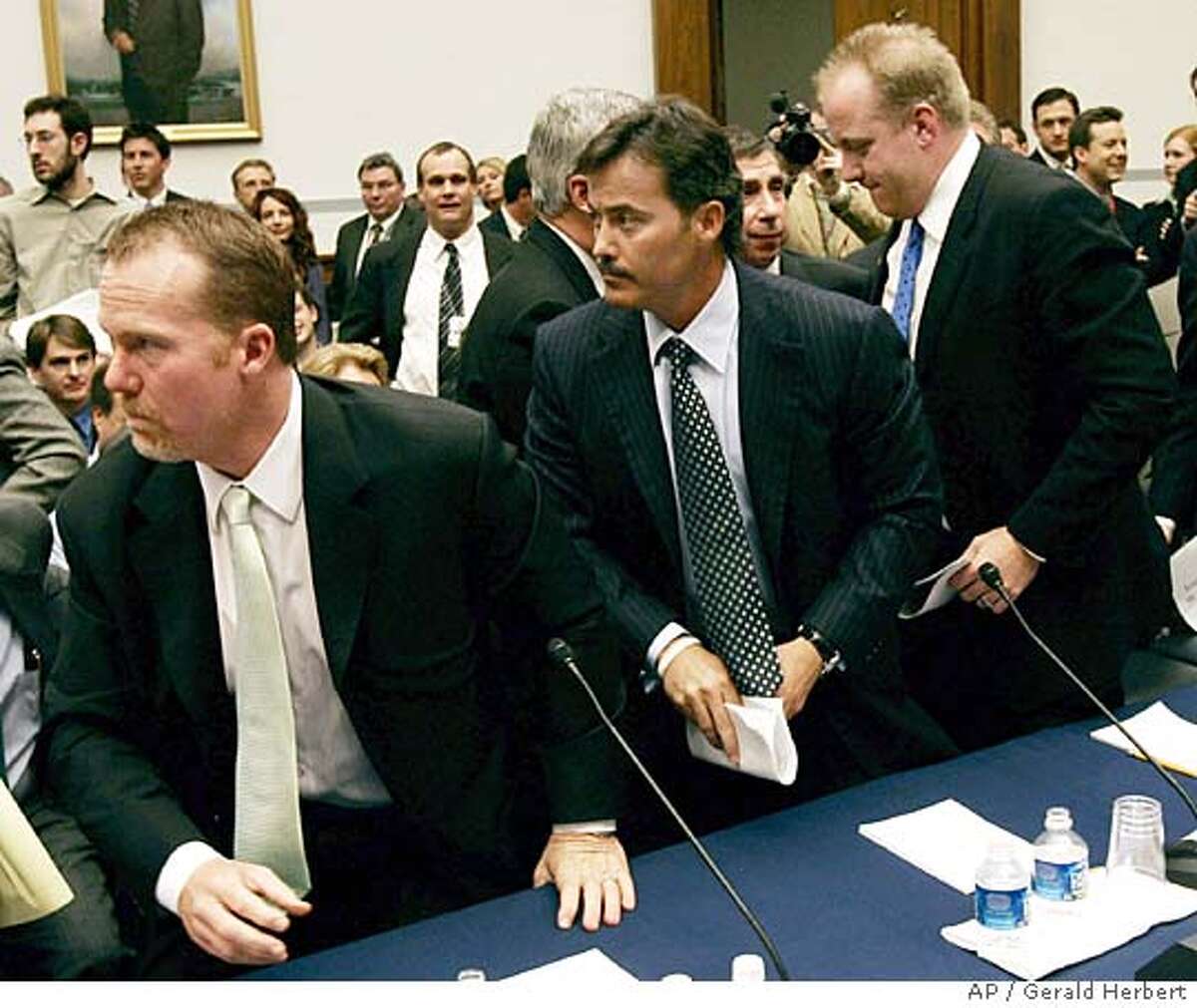 Former Oakland Athletic and St. Louis Cardinal Mark McGwire, left, Baltimore Orioles' Rafael Palmiero, center, and Boston Red Sox Curt Schilling leave the witness table during a break in the hearing on Capitol Hill to examine the use of steroids in professional baseball Thursday, March 17, 2005, in Washington. (AP Photo/Gerald Herbert)
