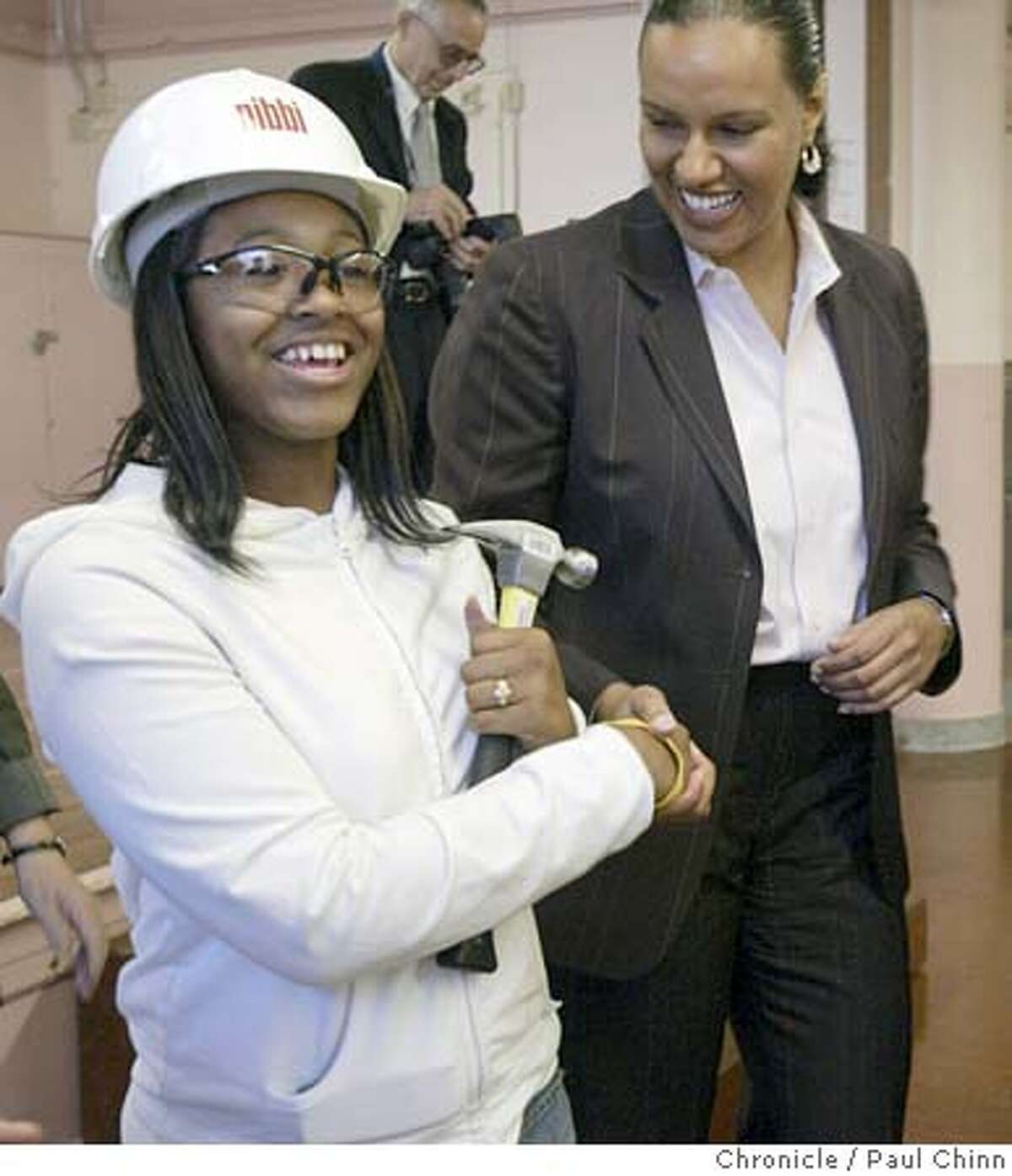 School Board Commissioner Heather Hiles (right) congratulates Sade Richardson for winning an informal nailing contest. The Building and Trades Union gives continuation high schools in San Francisco new shop classes and vocational skills training in a time when both are being sacrificed to academic classes and standardized test preparation. Ida B. Wells High School on 9/23/04 in San Francisco, CA. PAUL CHINN/The Chronicle