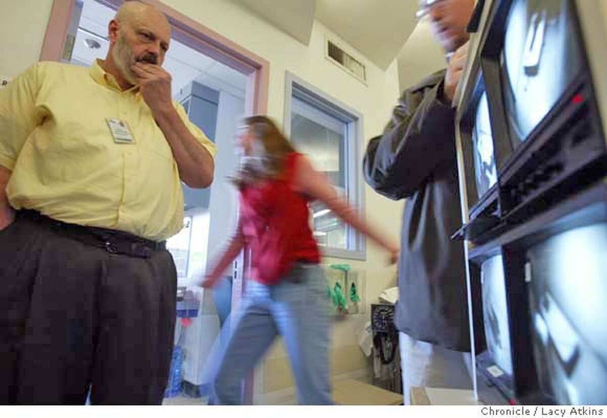 Dr. Robert Buckley watches his patients through television monitors to check their behavoir as they are in the isolation rooms in the PES of San Francisco General Hospital, March 5, 2004. Cuts to other psychiatric services around the city and bay area have dramatically increased the work load, challenges and risks for those at SF General. It is the city's only remaining emergency psychiatric facility and it is overwhelmed to the point that on many days and nights, patients have no beds or even chairs to sit on, March 5,2004. Event on 3/5/04 in SAN FRANCISCO. LACY ATKINS / The Chronicle