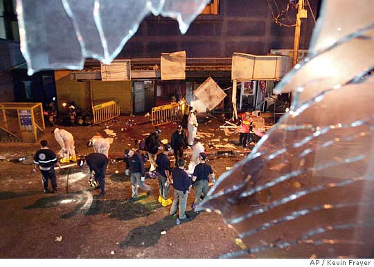 Israeli police inspect the scene of an explosion outside a nightclub near Tel Aviv's beach front promenade late Friday Feb. 25, 2005. A suicide bomber carrying explosives blew himself up in a crowd of Israelis waiting outside the nightclub before midnight Friday, killing at least four other people, wounding dozens and shattering an unofficial Mideast truce.(AP Photo/Kevin Frayer)