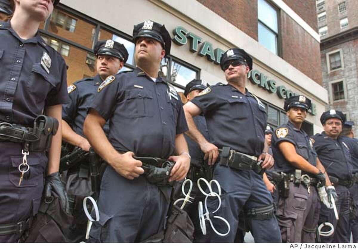 New York police form a barrier in front of a during a Starbucks coffee shop during a demonstration against Starbucks' workplace practices and the Bush administration's alleged support for the chain's anti-union practices in New York Saturday Aug. 28, 2004. The Republican National Convention is scheduled to begin in New York on Monday. (AP Photo/Jacqueline Larma)