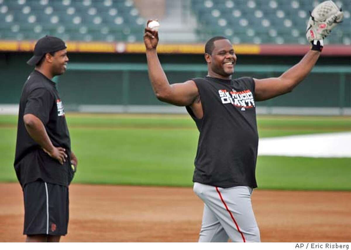 San Francisco Giants' new closing pitcher Armando Benitez, right, smiles while winding up to throw as Giants' pitcher Jerome Williams, left, looks on at Scottsdale Stadium in Scottsdale, Ariz., Thursday Feb. 17, 2005. The pair did some light throwing on the field after reporting for spring training. The Giants' first workout for pitchers and catchers is on Friday.(AP Photo/Eric Risberg)