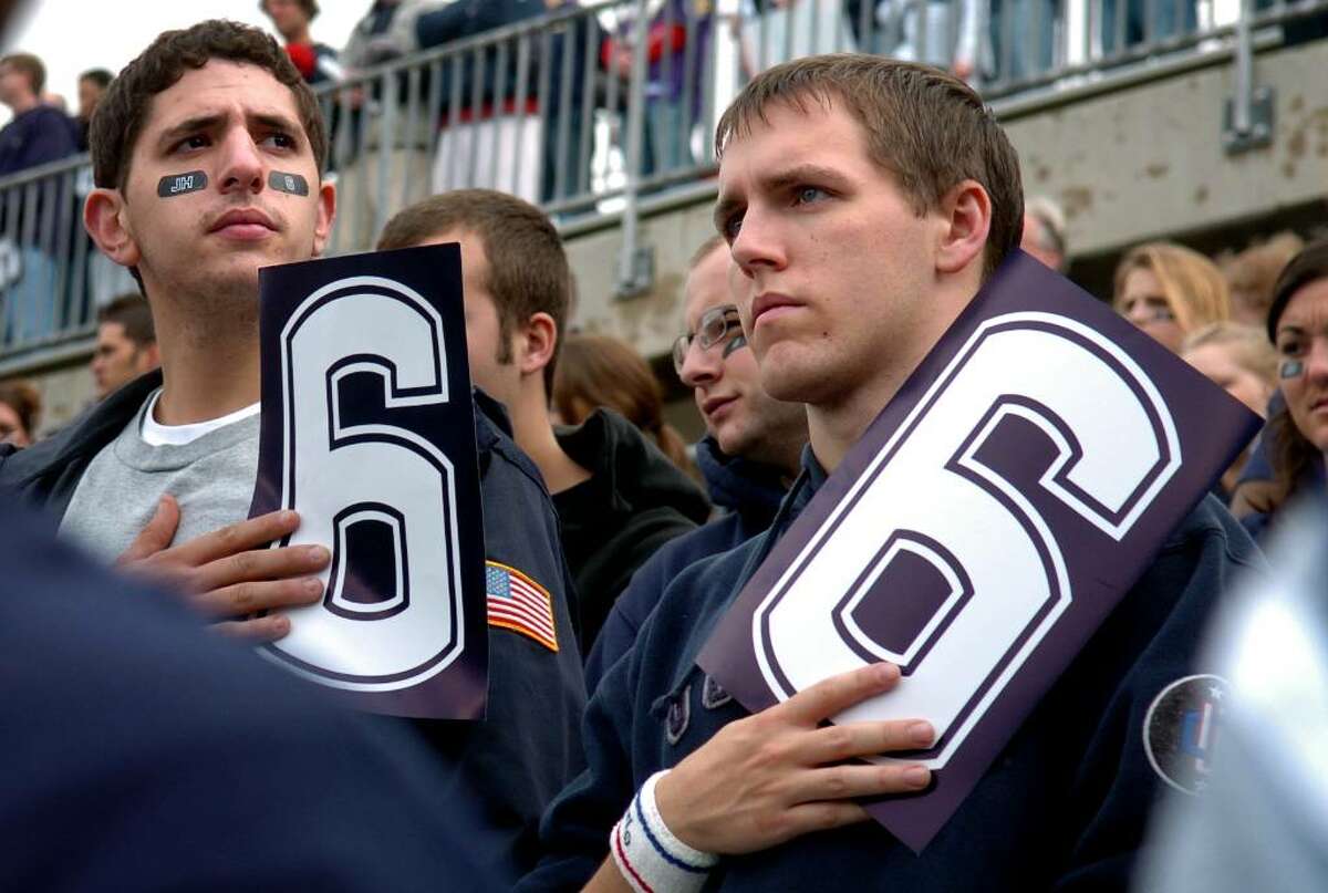 UConn seniors Craig Woodhouse, left, and Brian Keenan hold "6" signs in honor of Jasper Howard's jersey number before the start of Saturday's contest against Rutgers.