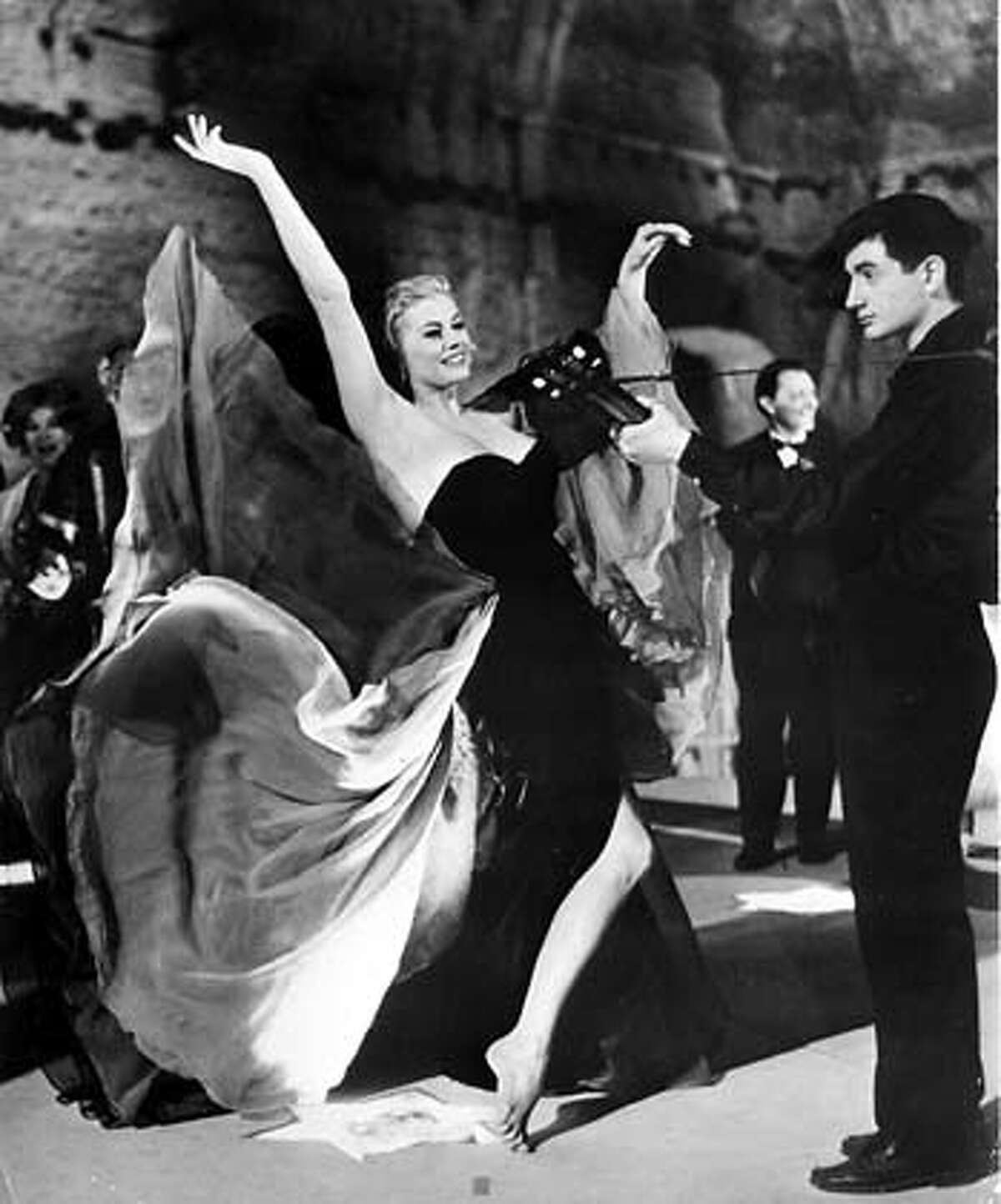 Anita Ekberg, as an American starlet, dances in the streets of Rome in Federico Fellini�s �La Dolce Vita.�