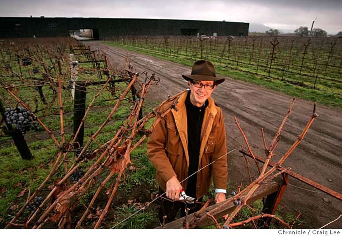 Christian Mouiex, who directs Chateau Petrus in Bordeaux, Dominus in Yountville, Napa Valley and many other brands for his French winemaking family. This photo was taken at Dominus winery in Yountville. Photo of Christian Mouiex in his vineyard with Dominus winery behind in the background. Event on 12/10/04 in Yountville. Craig Lee / The Chronicle