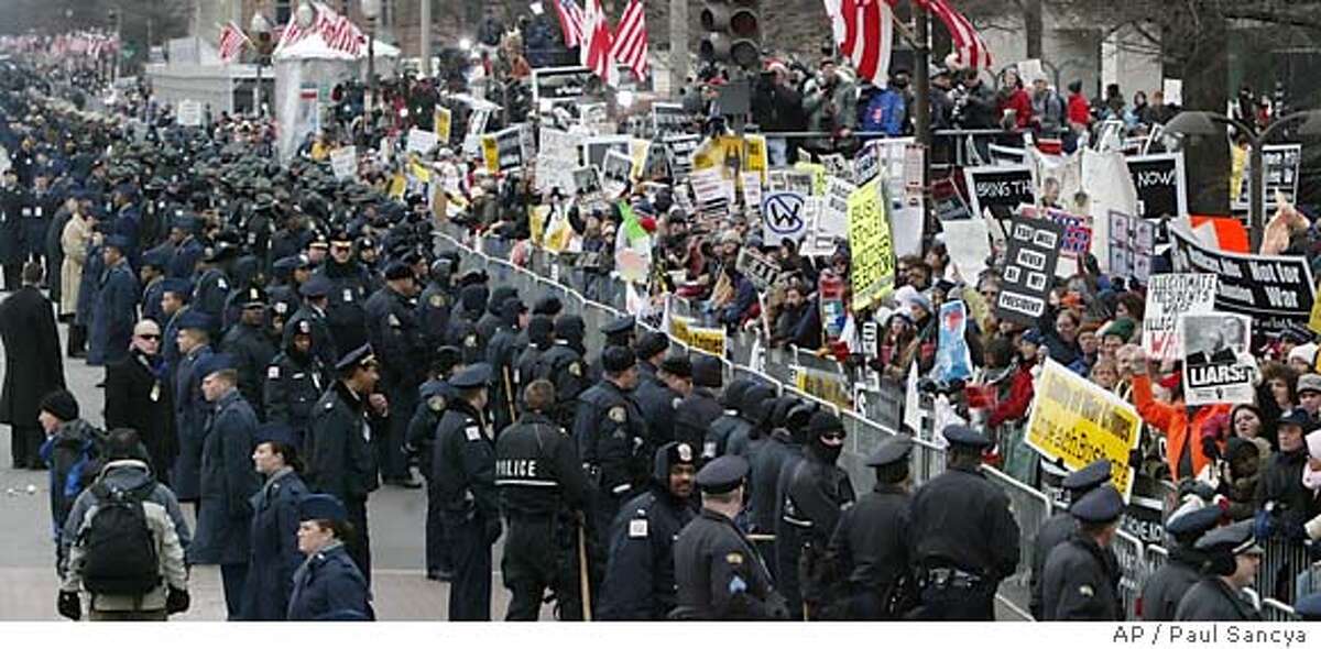 Barricades and a heavy security lineup separates demonstrators from the inaugural parade along the route to the White House from the Capitol in Washington Thursday, Jan. 20, 2005. (AP Photo/Paul Sancya)