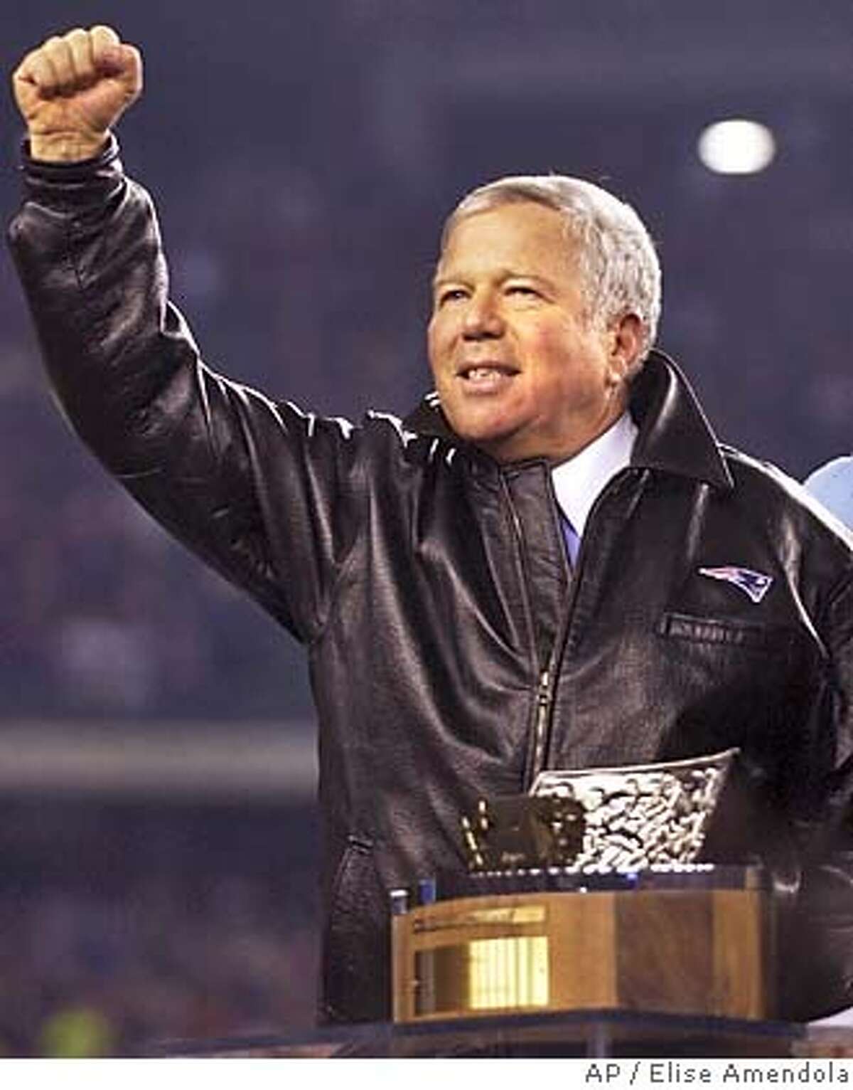 New England Patriots owner Robert Kraft throws a fist to the crowd with the Lamar Hunt Trophy in foreground after their 24-14 victory over the Indianapolis Colts for the at Gillette Stadium in Foxboro, Mass. Sunday, Jan. 18, 2004. (AP Photo/Elise Amendola)