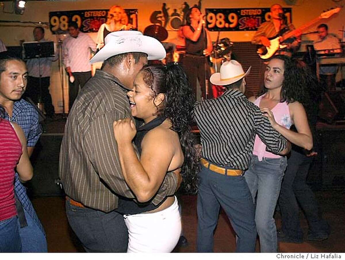 Erika Chavez (middle) dancing with Juan Blas as Los Signos Durangenses plays at El Rancho restaurant and night club on Monument Blvd. Fernando Orozco (with striped black and white shirt) on right. Shot on 7/9/04 in Concord. LIZ HAFALIA / The Chronicle