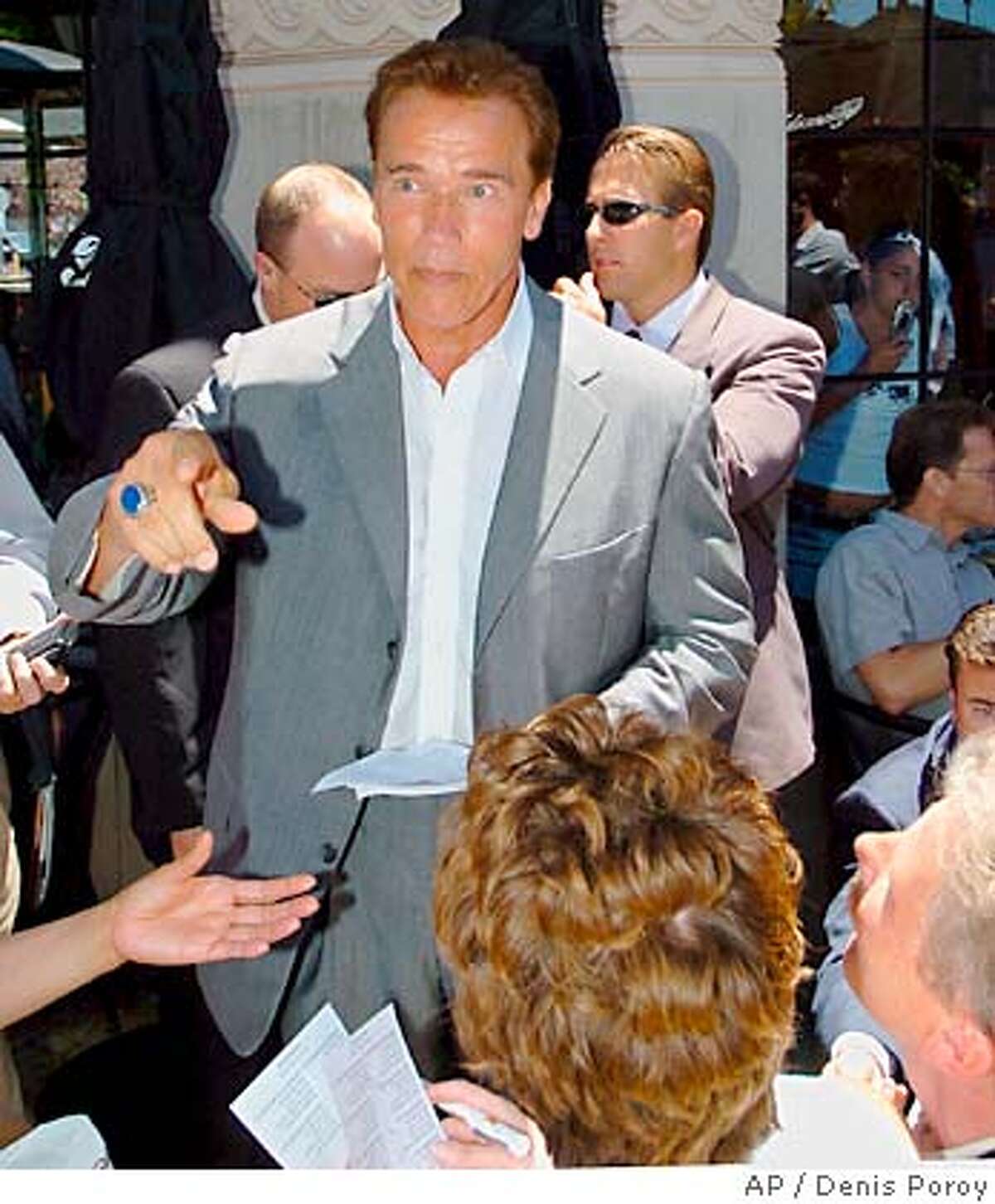 California Gov. Arnold Schwarzenegger talks with patrons as he passes out flyers for his California state budget at the Cheesecake Factory restuarant in San Diego Wednesday, July 21, 2004. (AP Photo/Denis Poroy)