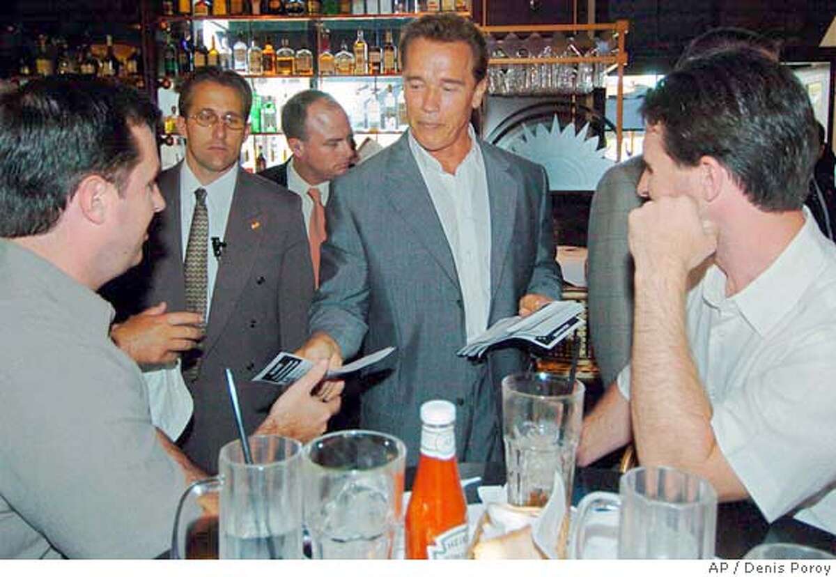 California Gov. Arnold Schwarzenegger passes out fliers for his State budget at the Cheesecake Factory restuarant in San Diego Wednesday, July 21, 2004. (AP Photo/Denis Poroy)