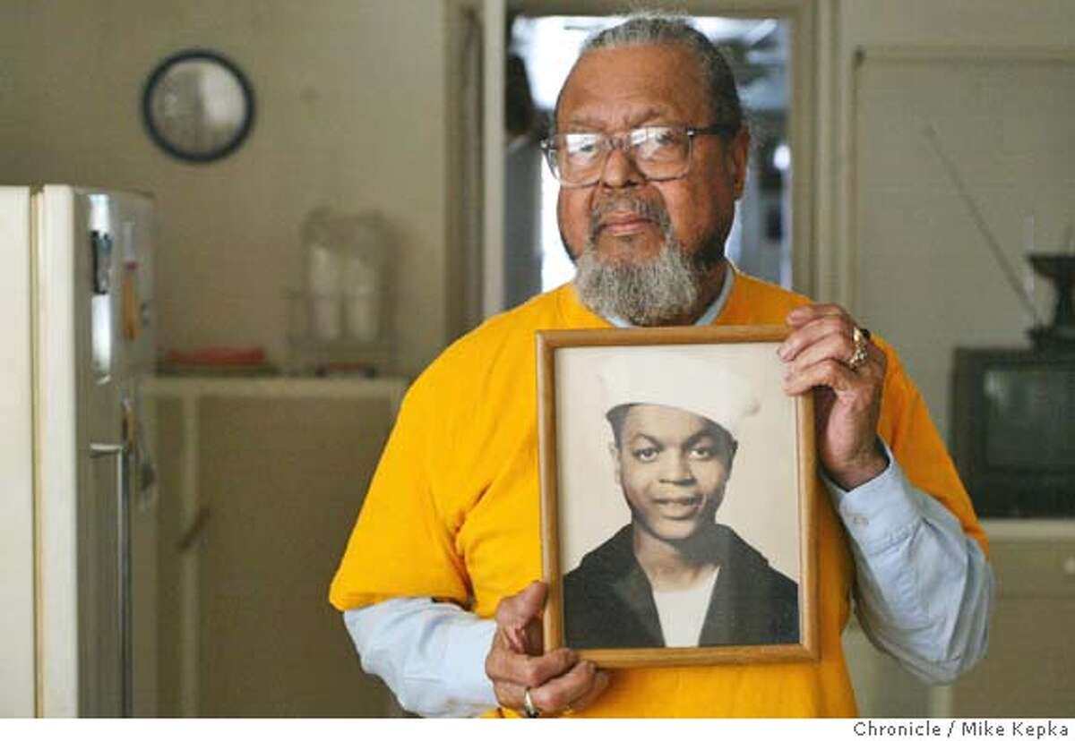 Holding a picture take in his naval uniform when he was 18, Robert Edwards, 78, of Oakland is one of just a few remaining survivors from a large explosion at the Port of Chicago, near what is now Pittsburg, on July 17, 1944. The ammunitions blast killed hundreds of soldiers and wounded as many as 400. MIKE KEPKA/The Chronicle
