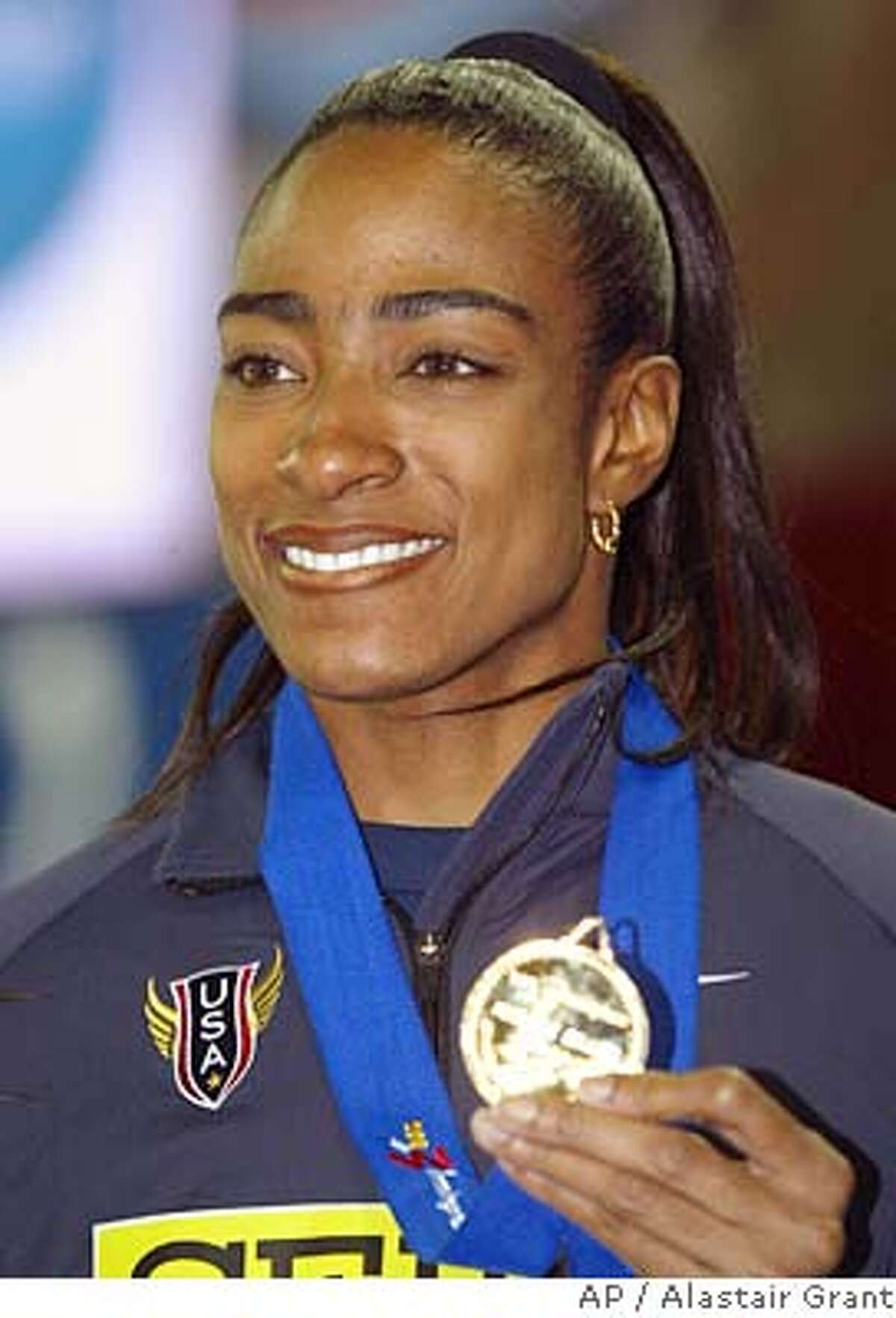 ** FILE ** Michelle Collins, of the United States, displays her gold medal that she won in the Women's 200 meters at the World Indoor Athletics Championships in Birmingham, England, Saturday, March 15, 2003. The U.S. Anti-Doping Agency has notified Collins that it will seek a lifetime ban against her for alleged drug violations, Collins' lawyer said Wednesday, June 23, 2004. (AP Photo/Alastair Grant,file) Ran on: 06-24-2004 Ran on: 06-24-2004 MARCH 15, 2003 FILE PHOTO