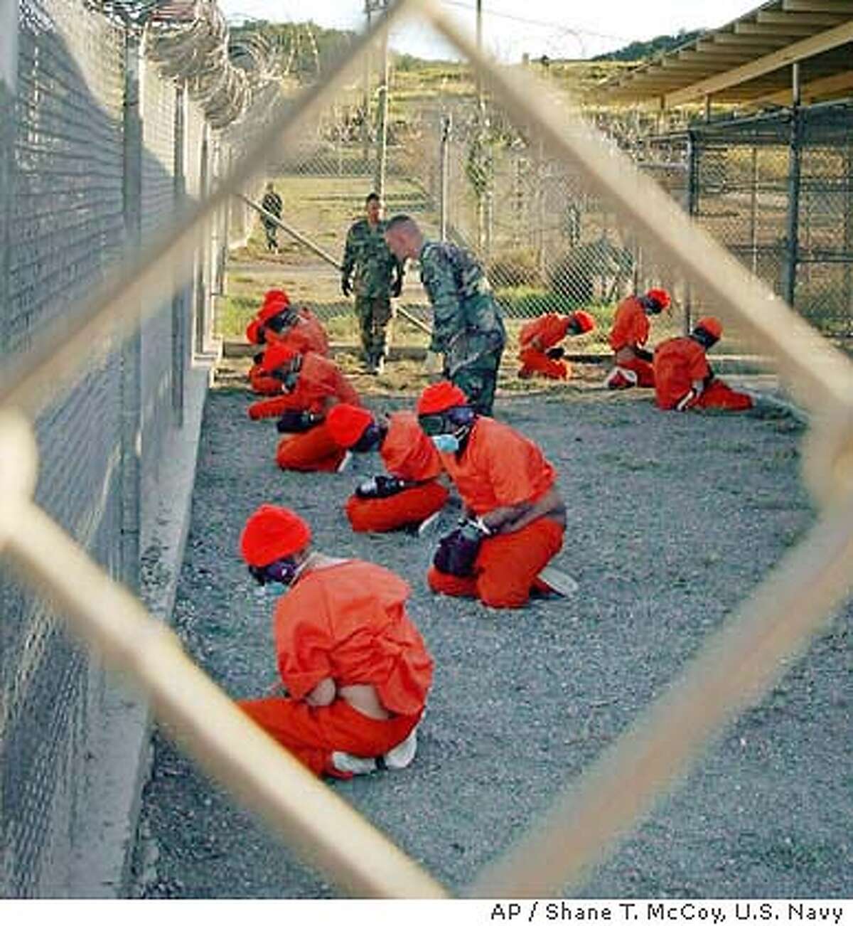 ** FILE ** Taliban and al-Qaida detainees sit in a holding area at Camp X-Ray at Guantanamo Bay, Cuba, during in-processing to the temporary detention facility in this Jan. 11, 2002 file photo. Controversy over prisoner abuse at U.S.-run prisons in Iraq and Afghanistan has left the Guantanamo Bay, Cuba, detention facility for terrorist suspects largely untouched. but that may soon change. A senior Navy admiral who briefly visited Guantanamo Bay in early May has recommended a more in depth look at how prisoners were treated there. (AP Photo/U.S. Navy, Shane T.McCoy)