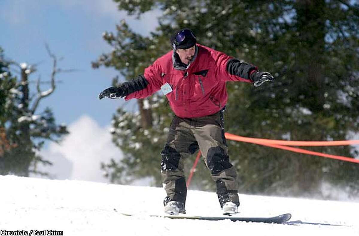 Slip-sliding away: The author makes his stand atop a snowboard. Chronicle photo by Paul Chinn
