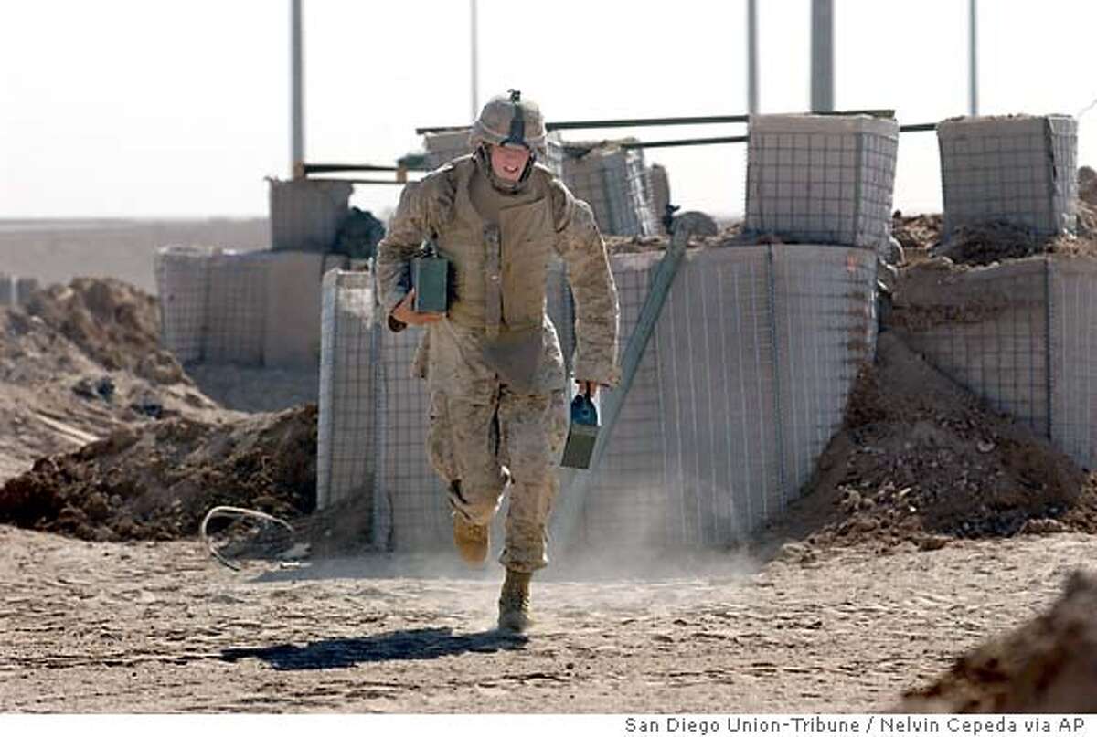 Marine Lance Cpl. Joseph Williams rushes to the front line with ammunition in eastern Fallujah, Iraq, Thursday, June 24, 2004. Williams along with other Marines were engaged in a fire fight that lasted more than eight hours and continued into the evening hours. (AP Photo/San Diego Union-Tribune / Nelvin Cepeda), ** , ONLINE OUT, NO ARCHIVING, SAN DIEGO COUNTY OUT, TV OUT, MAGS OUT, NO FORNS**