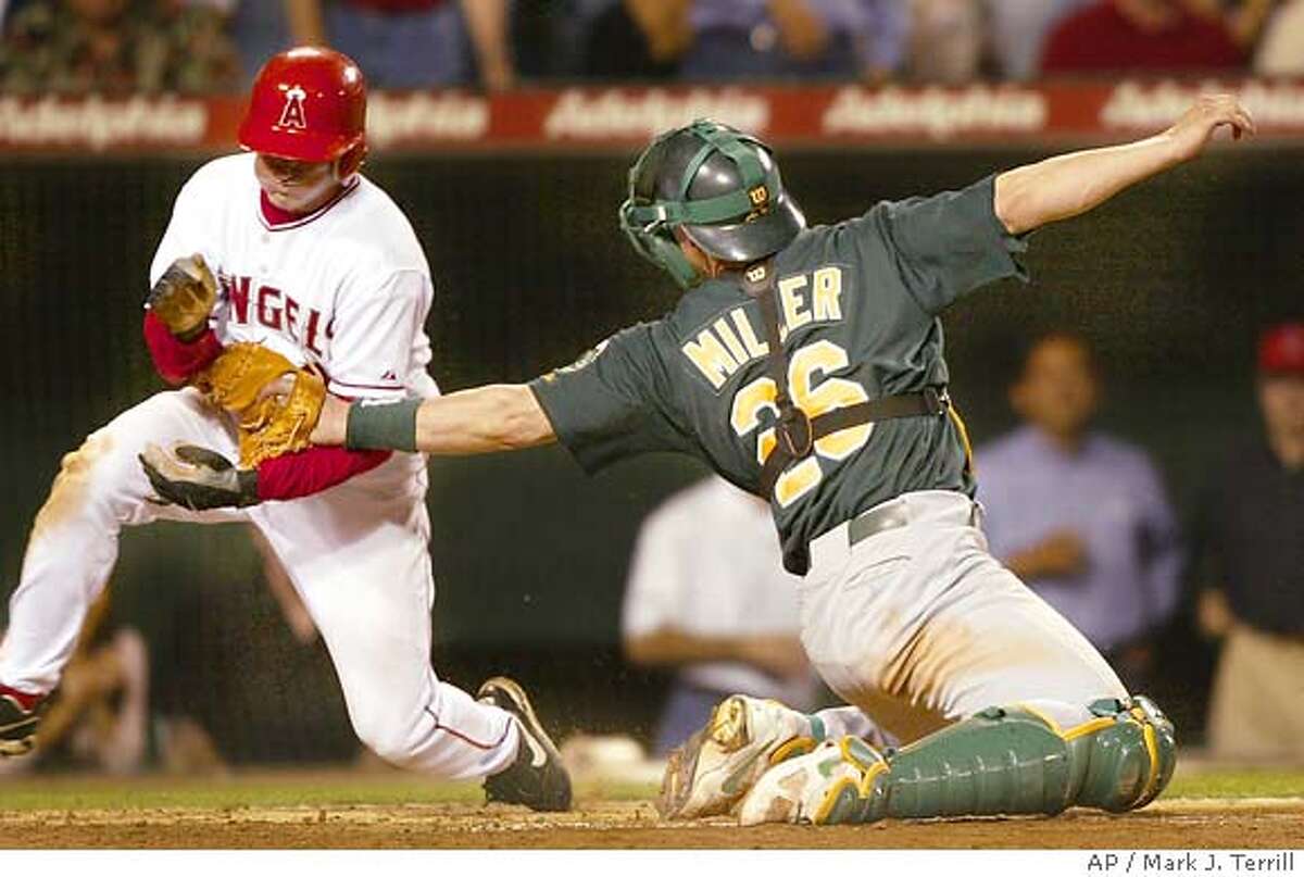 Anaheim Angels' David Eckstein is tagged out by Oakland Athletics catcher Damian Miller while trying to score on a double by Vladimir Guerrero during the sixth inning Wednesday night, June 23, 2004, in Anaheim, Calif. (AP Photo/Mark J. Terrill)