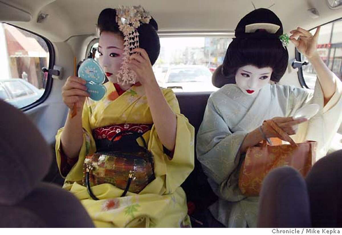 Japanese Geisha, Umechika, 20, and Umeha, 25, touch up their makeup in the back seat of a van during a day of tourism after helping with the Geisha exhibit at the Asian Art Museum. 6/23/04 in San Francisco. Mike Kepka / The Chronicle