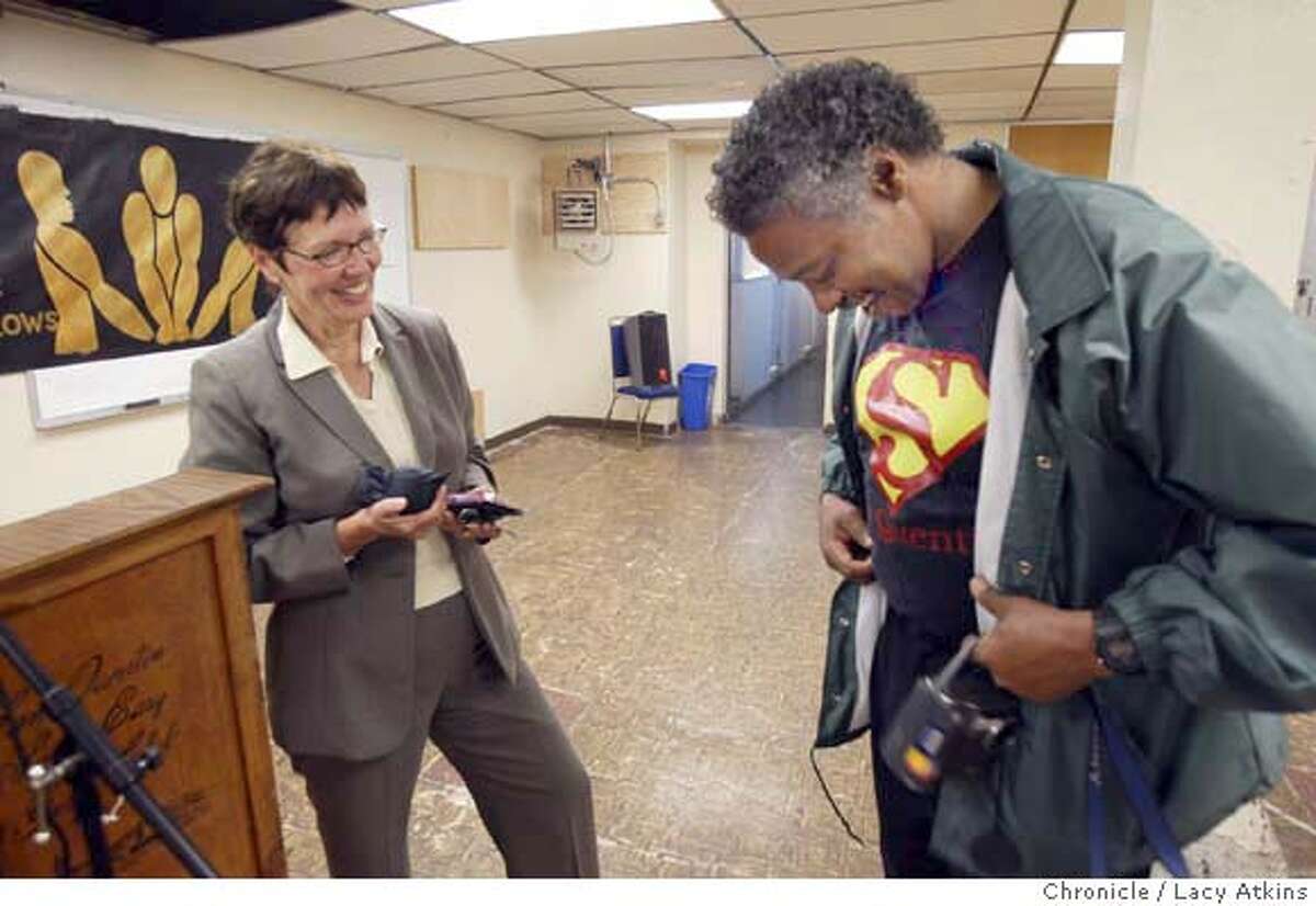 California Department of Corrections director Jeanne Woodford talks to Vernell Crittendon as he shows off his "San Quentin Superman" t-shirt during her visit, Saturday May 1 2004. LACY ATKINS / The Chronicle