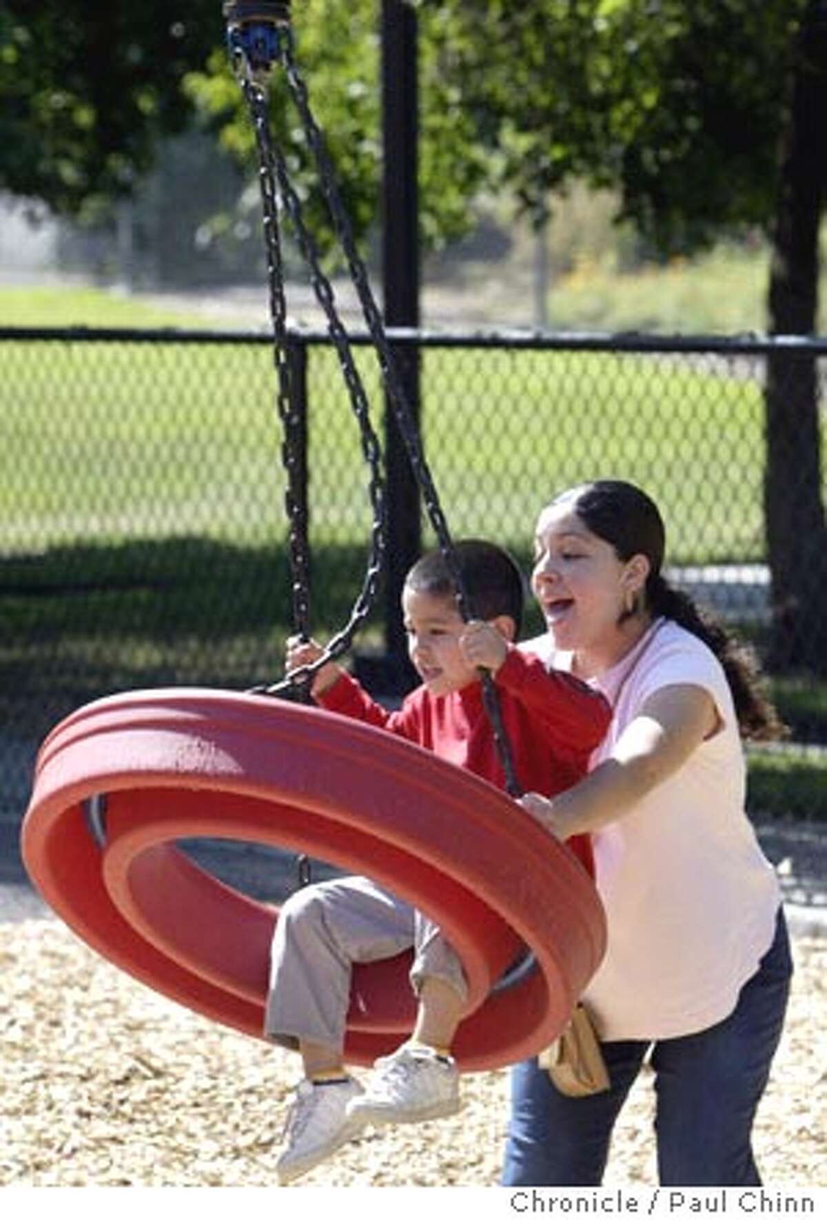 Anna Gomez pushes her son, Adrian, on a swing at the aging playground in Hillcrest Park. Chronicle photo by Paul Chinn