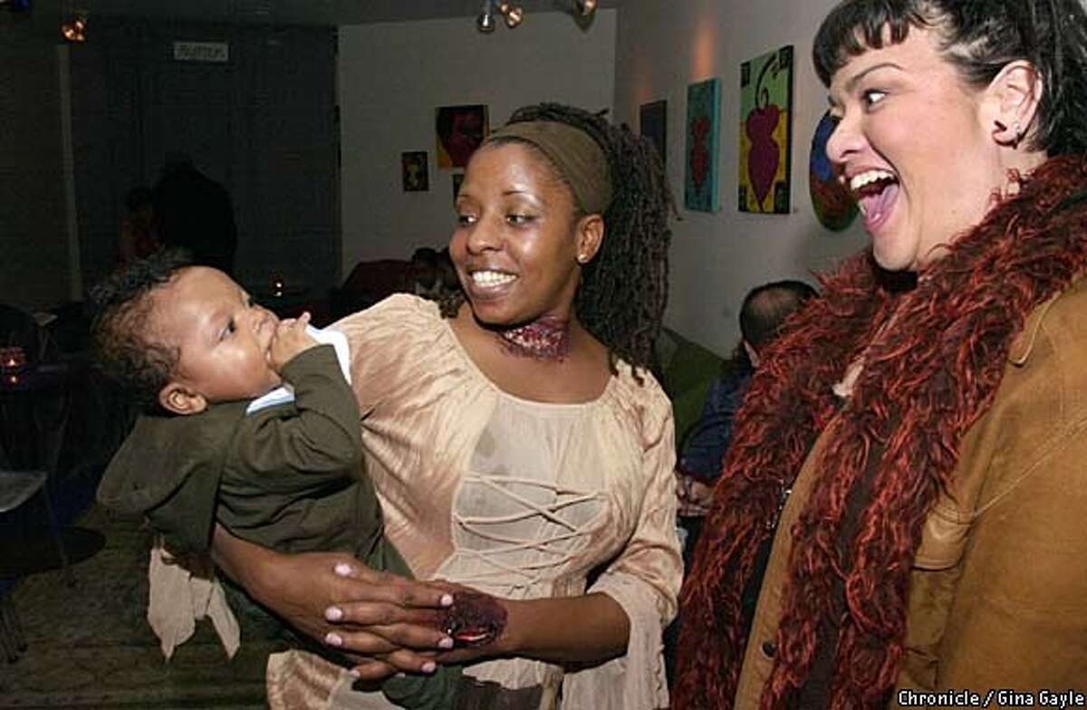 Sonia Whittle, a host of the Black Box's open mike and poetry slam, holds her 5-month-old son, Ajai, as she talks to Suashia Solano. Chronicle photo by Gina Gayle