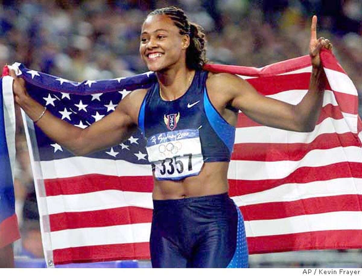Sprinter Marion Jones of the United States celebrates with an American flag after winning the gold medal in the 100 meters at the Olympics in Sydney, Australia Saturday, September 23, 2000. Jones won with a time of 10.75 seconds. (AP Photo/CP, Kevin Frayer) DIGITAL IMAGE