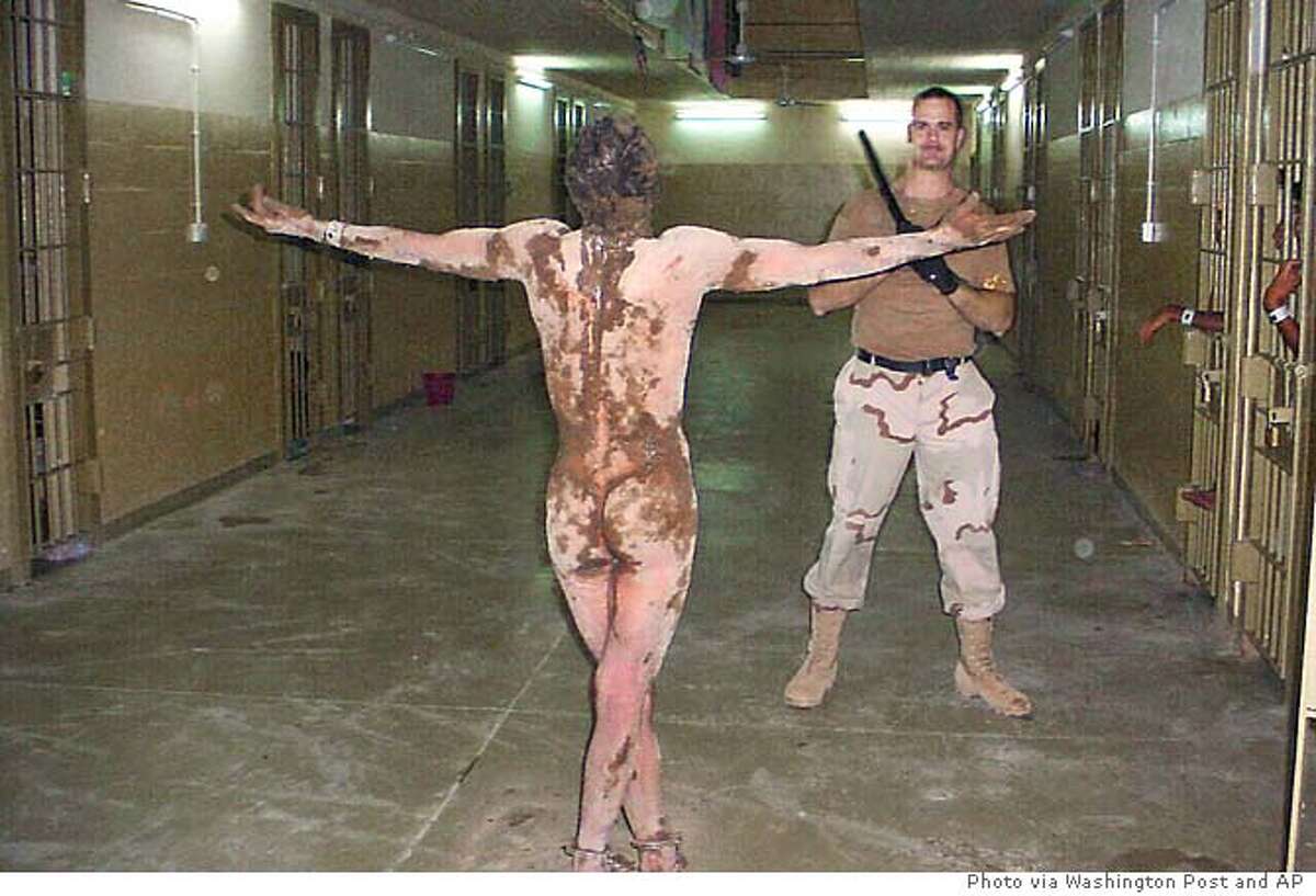In this undated still photo, a naked Iraqi detainee appears to be cuffed at...