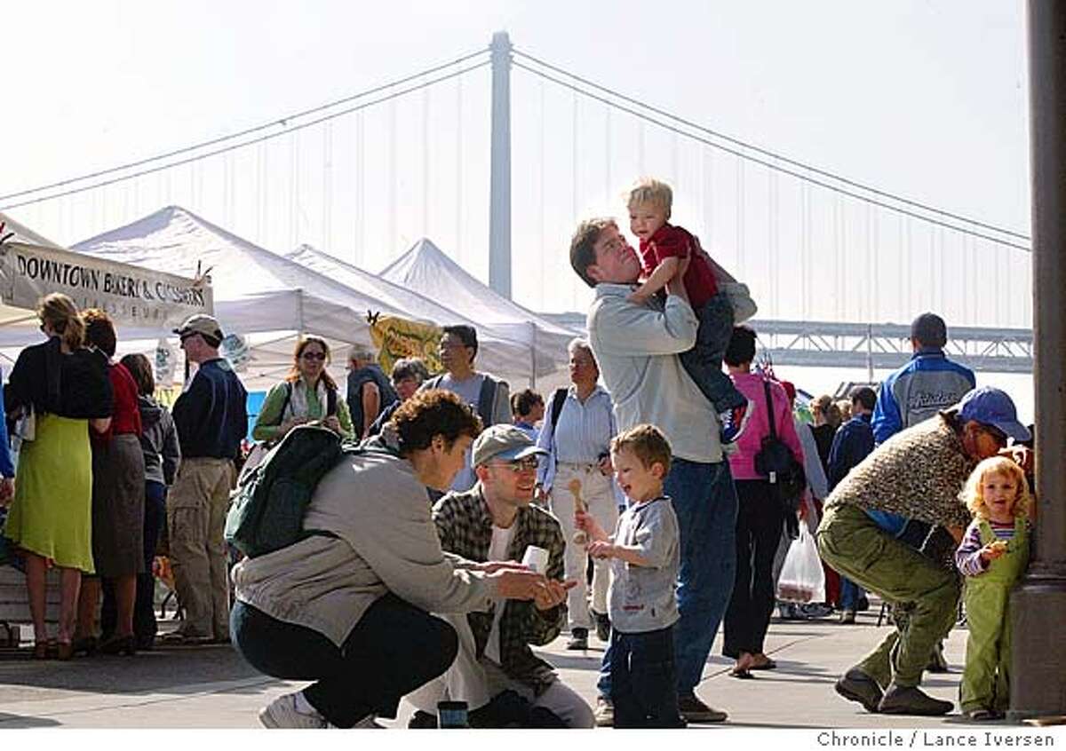 FERRYPLAZA19_063_LI.JPG event on 5/1/04 in SAN FRANCISCO With the Bay Bridge as a backdrop shoppers stroll through the Ferry Building Plaza home of the Farmers Market. The market is open from 8 a.m.-1 p.m. on Saturdays only. By Lance Iversen/The San Francisco Chronicle