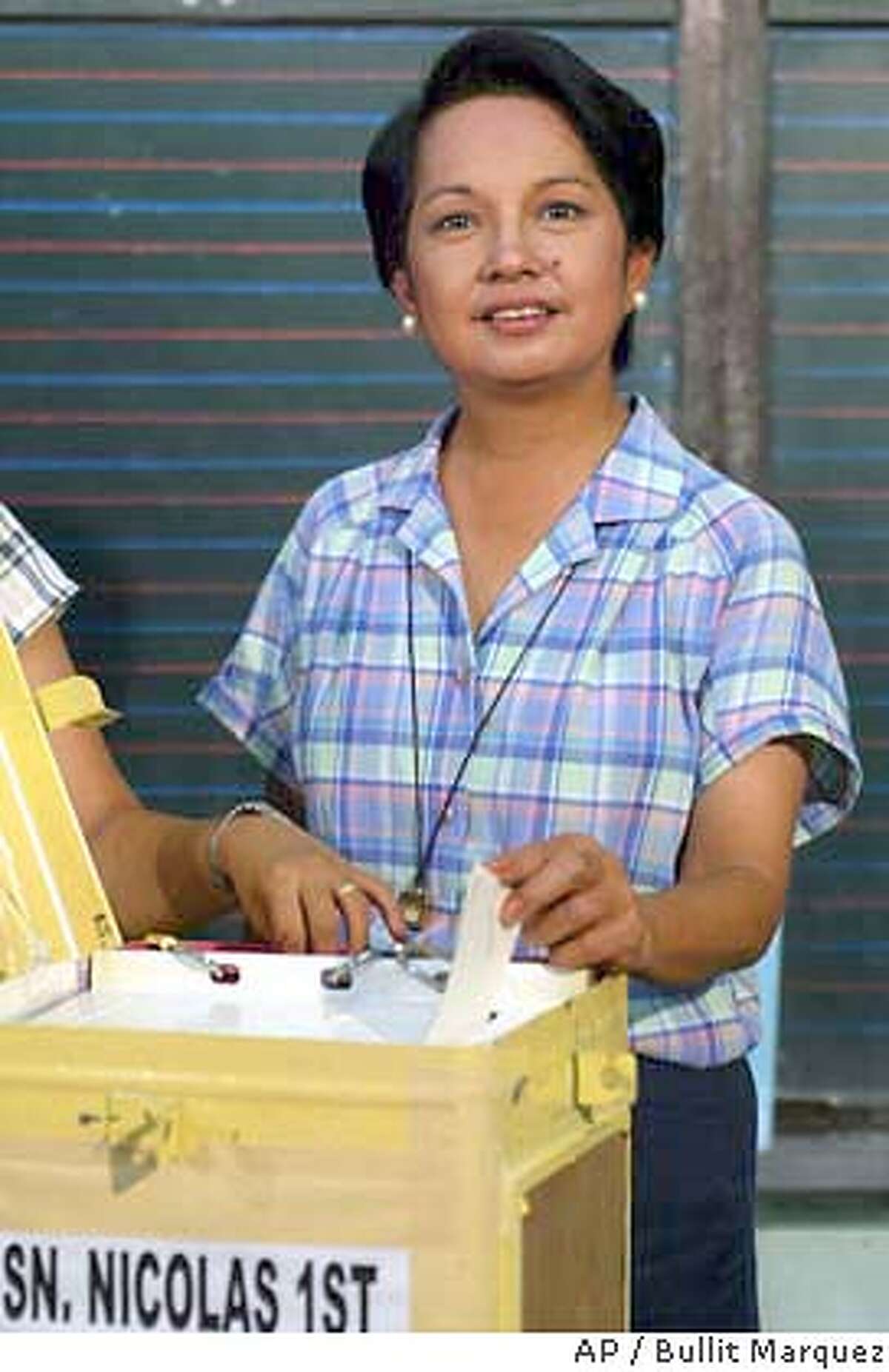 Philippine President Gloria Macapagal Arroyo casts her ballot at her hometown of Lubao in Pampanga province in northern Philippines, Monday May 10, 2004. Filipinos vote for their next president amid high security and scattered reports of violence in a race pitting incumbent Arroyo who strongly backs the U.S. war on terror against Fernando Poe, Jr., a film star, whose best friend, former President Joseph Estrada, lost the job in disgrace three years ago. (AP Photo/Bullit Marquez)