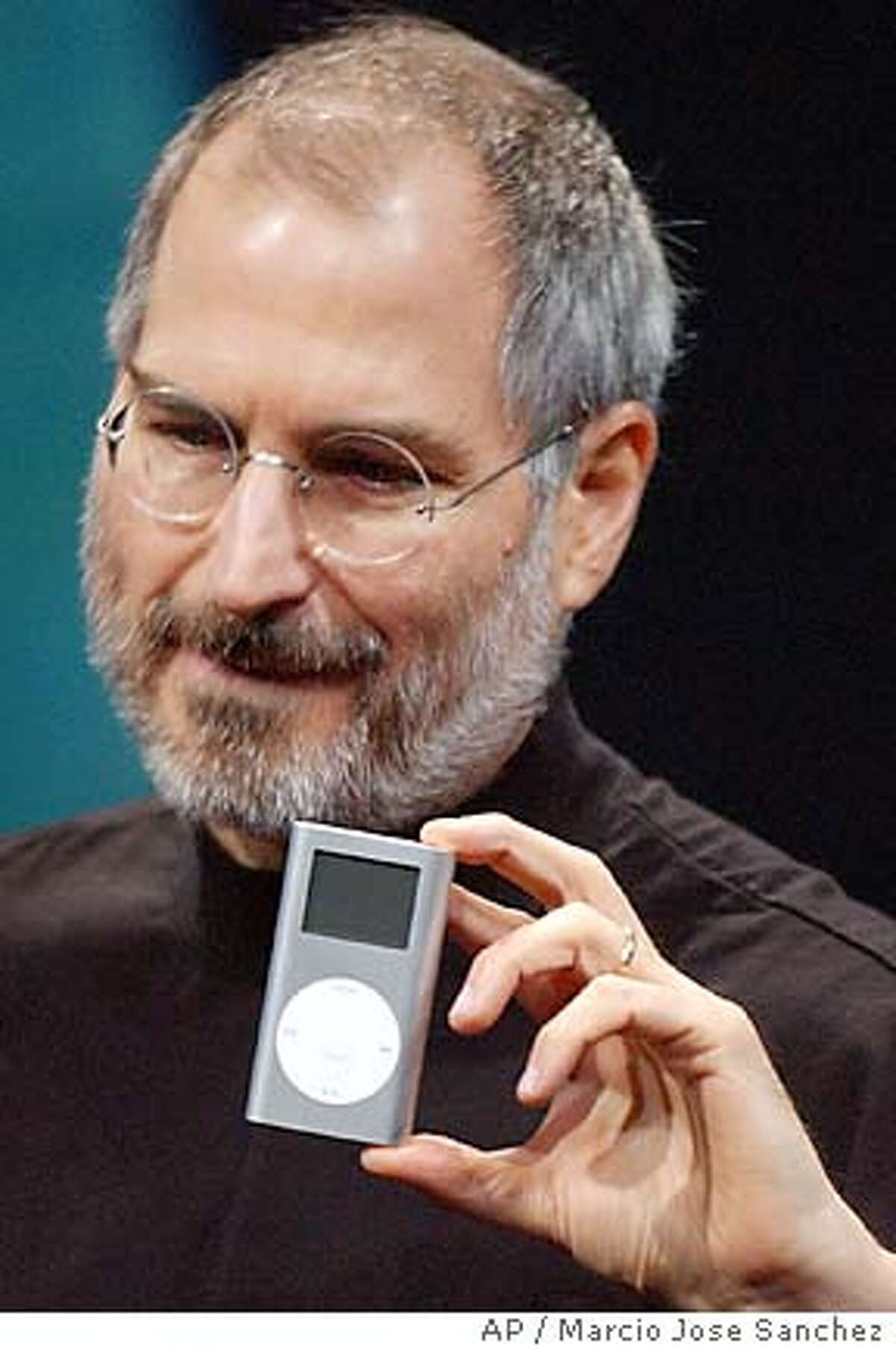 Apple CEO Steve Jobs displays his company's new product, the Mini-Ipod, at the Macworld Conference and Expo in San Francisco on Tuesday, Jan 6, 2004. Associated Press photo by Marcio Jose Sanchez