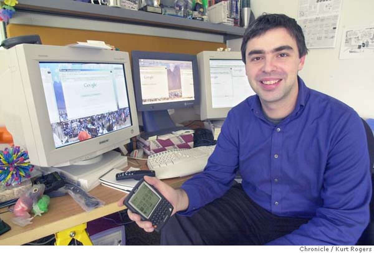 KIT31XXA-C-21DEC00-BU-KR Larry Page the Chief executive of GOOGLE in his office with his computer screans in the background and holding a RIM Blackberry 957 .Photo by Kurt Rogers