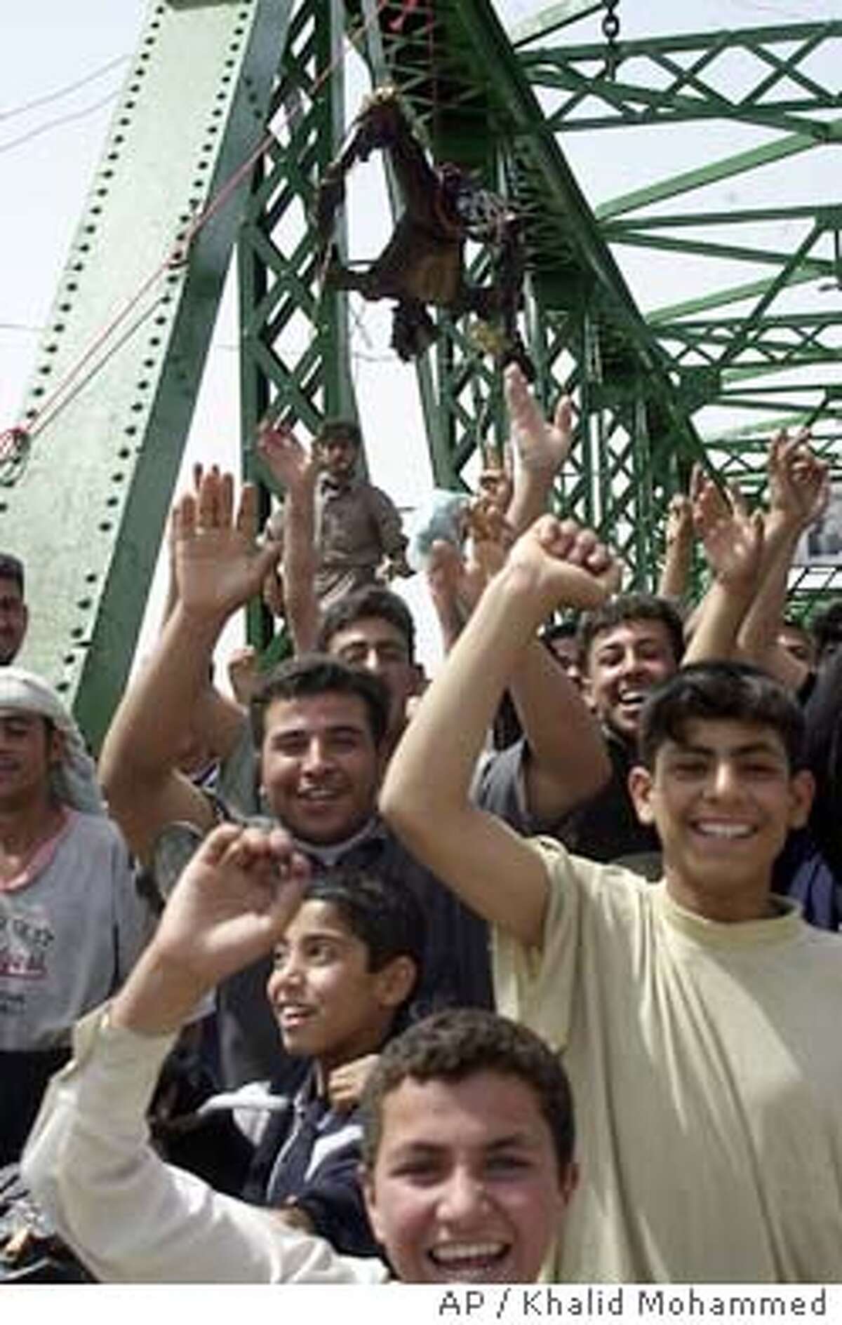 ** EDS NOTE GRAPHIC CONTENT **Iraqis chant anti-American slogans on a bridge over the Euphrates River where charred bodies are hanging in Fallujah, west of Baghdad, Wednesday March 31 2004. Enraged Iraqis in this hotbed of anti-Americanism killed four foreigners Wednesday, including at least one U.S. national, took the charred bodies from a burning SUV, dragged them through the streets, and hung them from the bridge spanning the Euphrates River. (AP Photo/Khalid Mohammed)
