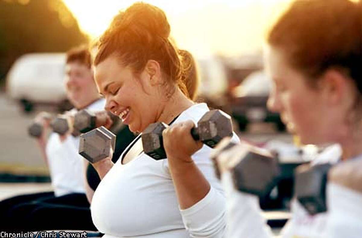 Monique Lesarre lifts weights in a sunrise class taught by fitness instructor Teresa Marchese. Marchese teaches a class for women that doesn't need a gym - just a nice, outdoor setting, such as at the Marina Green in SF. BY CHRIS STEWART/THE CHRONICLE