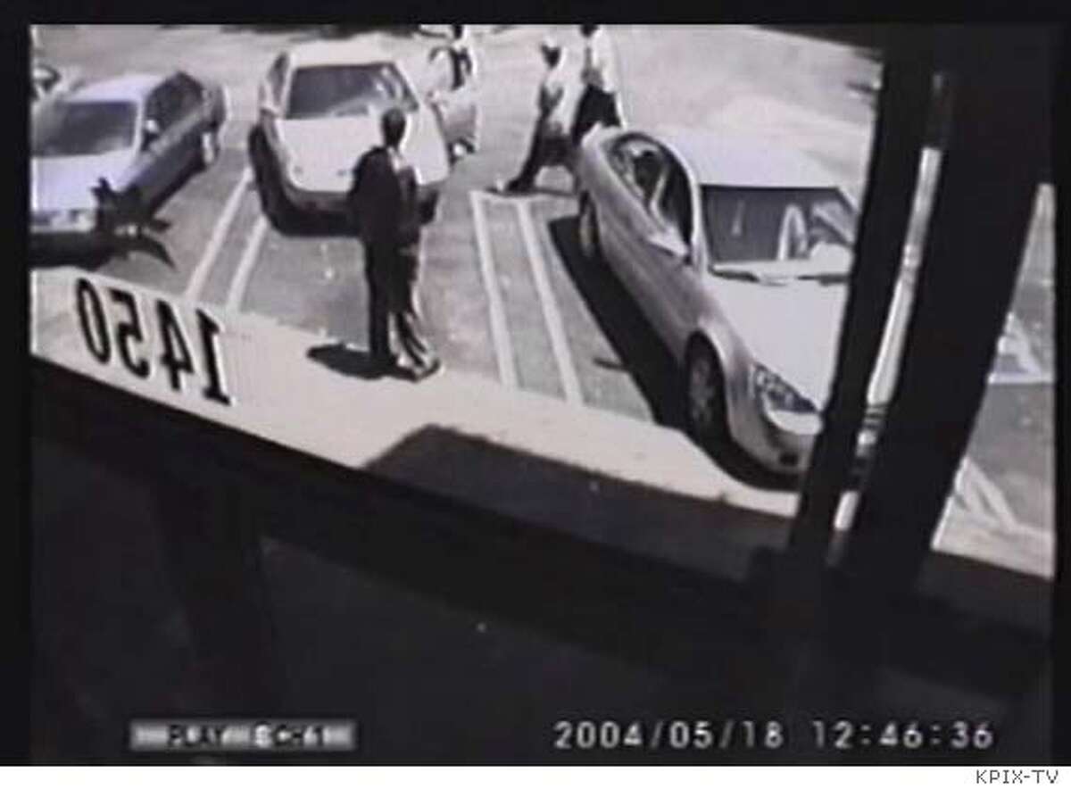 Freeze frames of a surveillance video shows the scene Tuesday of the killing of Chris Johnson in the parking lot of a strip mall in the Western Addition. Johnson's car is the middle vehicle, partially pulled out of a parking stall. Surveillance image via KPIX-TV