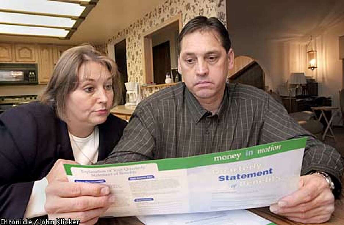 Diane and Joe Rinard who both work for PGE an Enron company look over "Money in Motion" an Enron quarterly report of employees investments, Wed. Jan. 16, 2002 at their home in Gresham Ore., but the only motion the Rinards have seen is a downward spiral to six cents a share. (Photo byJohn Klicker)