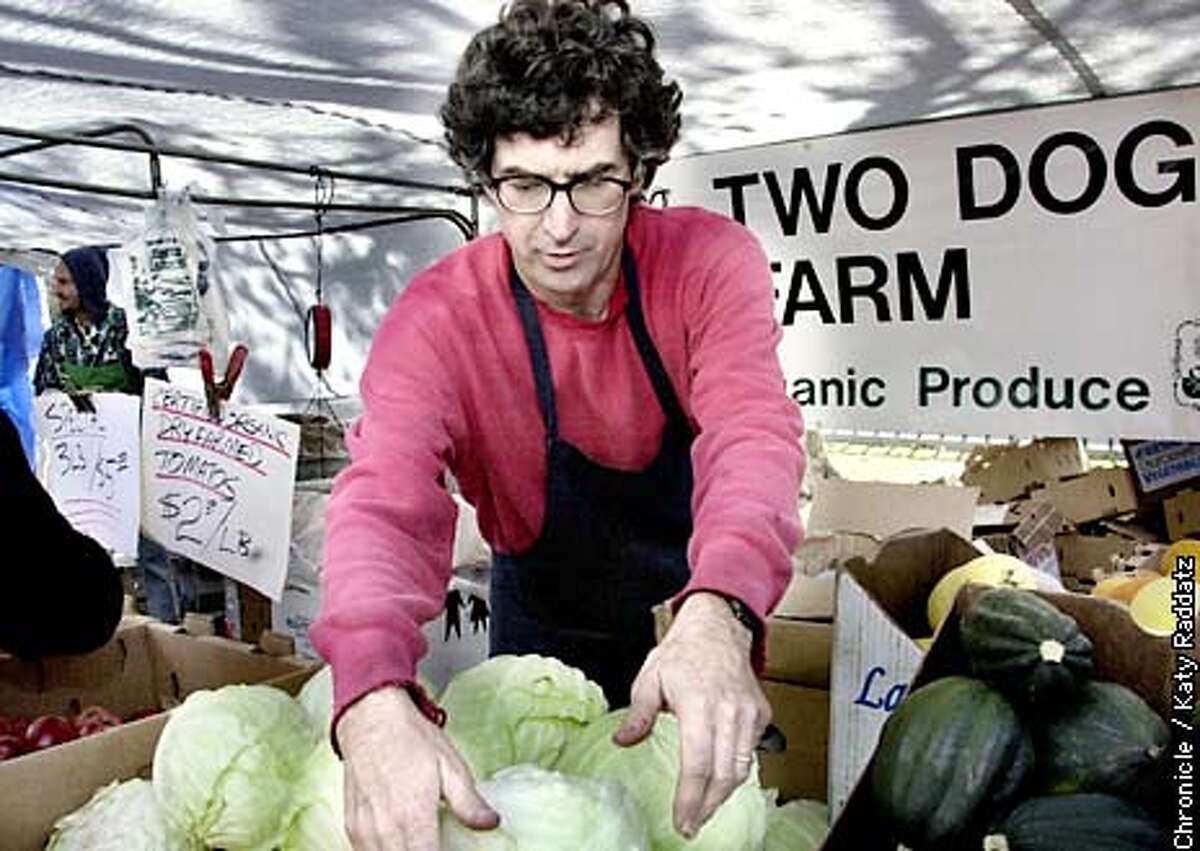 PHOTO BY KATY RADDATZ--THE CHRONICLE Story about the boom in the organic food industry. SHOWN: At the Civic Center Farmers' Market in San Francisco, we find Mark Bartle, who owns Two Dog Farm, sprucing up his organic cabbages.
