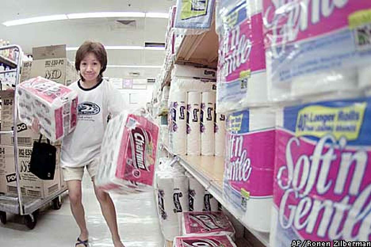 Shopper Reiko Chinei stocks up on toilet paper at Star Market, Tuesday, Oct. 1, 2002, in Honolulu. A drawn out work stoppage at ports on the West Coast could result in a shortage of consumer goods in Hawaii. Hawaii Gov. Cayetano has asked the Pacific Marine Association and the dockworkers union for an exemption that would allow goods and supplies to be shipped to Hawaii. Cayetano says a prolonged labor dispute will have a devastating effect on the economy and morale of Hawaii. (AP Photo/Ronen Zilberman)