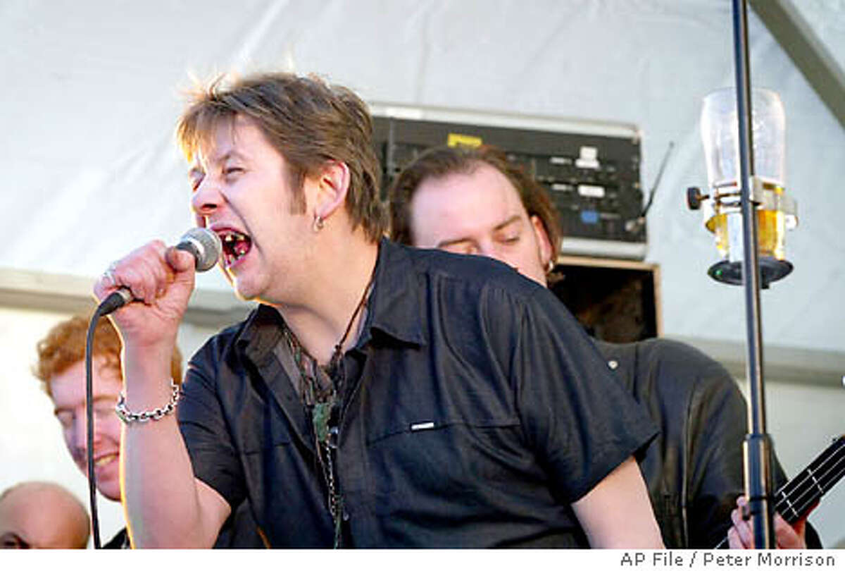 **FILE**Irish singer Shane MacGowan, former member of the Pogues, entertains the crowd at Belfast City Hall, Northern Ireland, on March, 17, 2004 during the St Patrick's Day festival. (AP Photo/Peter Morrison,file)