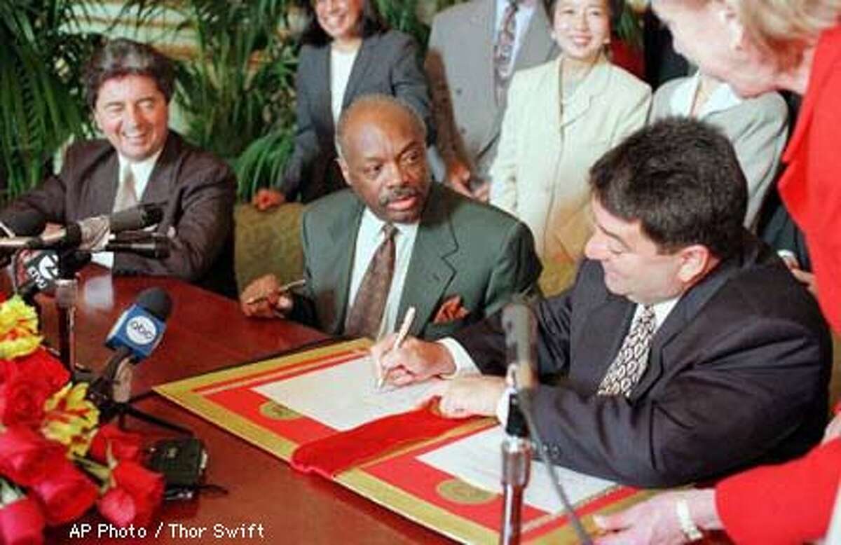 Edward DeBartolo Jr., right, owner of the San Francisco 49ers, signs an agreement in principle between the city and the team on the parameters of a stadium/mall project as Mayor Willie Brown, center, and Carmen Policy, 49ers president, look on at a news conference in San Francisco, Monday, May 5, 1997. Voters will decide June 3 if the city will issue a $100 million bond to aid in the construction of a $525 million stadium/mall. AP Photo by Thor Swift
