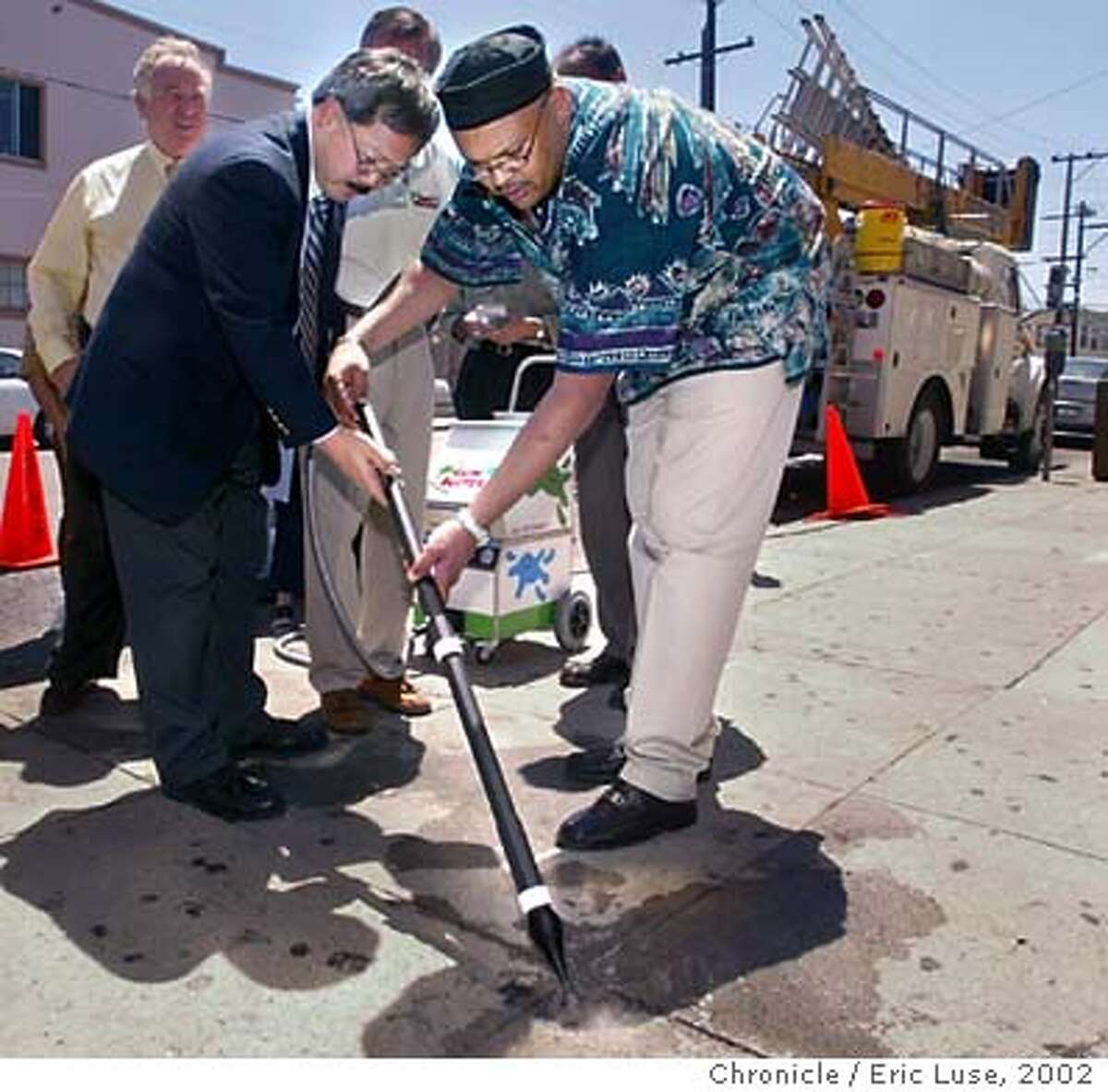 GUM-C-22JUL02-MT-EL Ed Lee , Director of Public Works along with the Deputy Director of Operations Mohammed Nuru work on their technique with the Gum Buster GUMCART. According to Nuru DPW is very excited about this new technology and will be recommending its use. BY ERIC LUSE/THE CHRONICLE