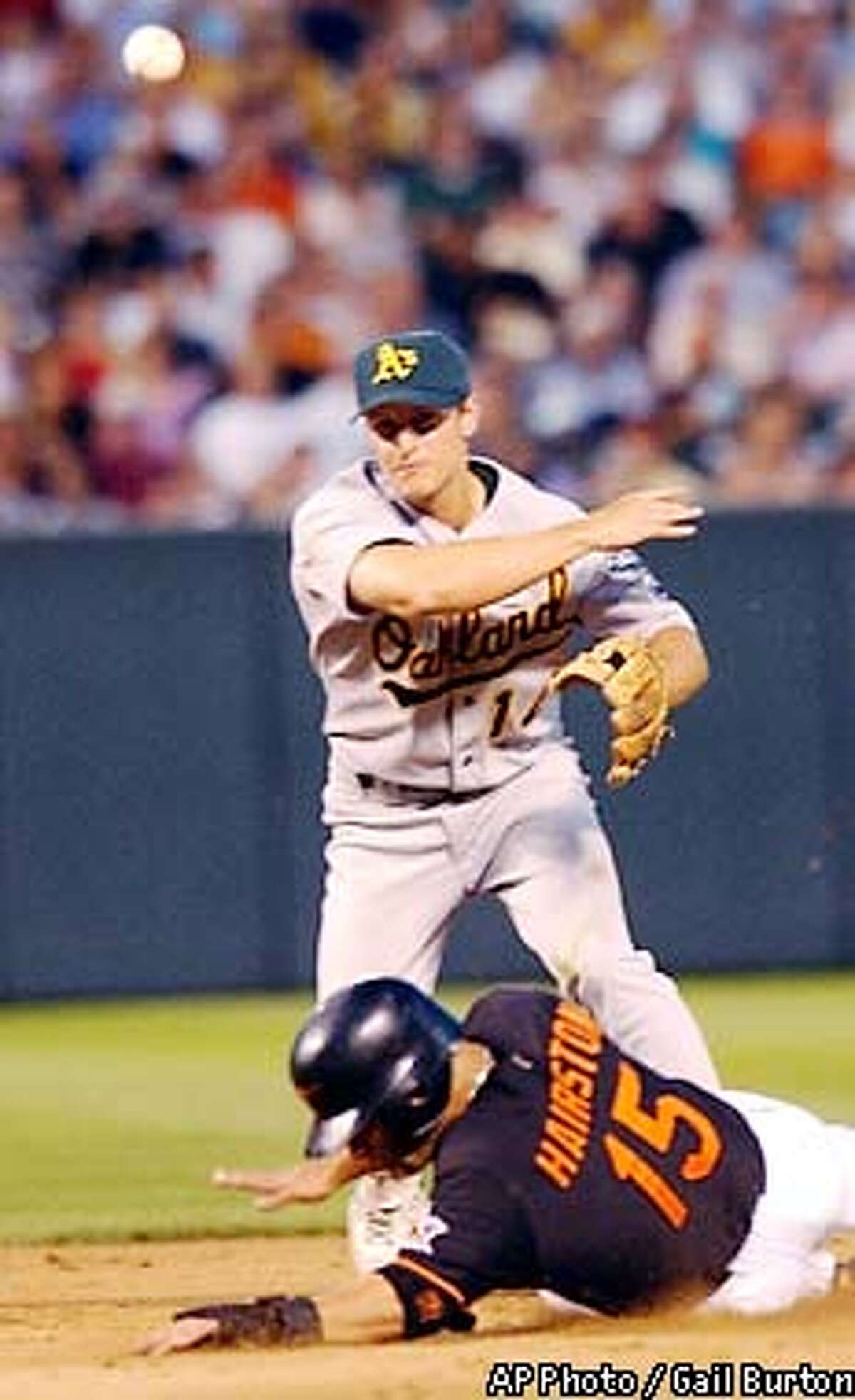 Oakland Athletics second baseman Mark Ellis, top, forces out Baltimore Orioles' Jerry Hairston (15) and throws to first to complete the double play on Melvin Mora in the fifth inning Friday, July 12, 2002, at Camden Yards in Baltimore. (AP Photo/Gail Burton)