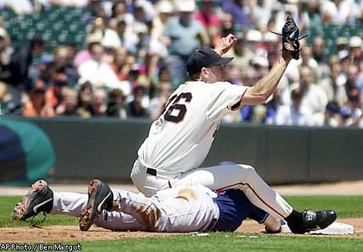 San Francisco Giants' Kirk Rueter sits on San Diego Padres' Mark Kotsay at third base in the first inning after Kotsay tried to advance on a foul ball by Ryan Klesko Wednesday, June 26, 2002, at Pacific Bell Park in San Francisco. Rueter covered third base as Giants third baseman Pedro Feliz fielded the foul ball. The Giants won the game 6-5 in twelve innings. (AP Photo/Ben Margot)