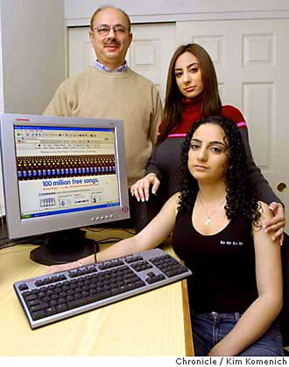 Raymond Maalouf (left) and daughters Kristina (center) and Michelle (seated) of Concord might have to pay the Recording Industry Association of America thousands of dollars after the association sued them for illegal downloading of copyrighted material. Ironically, the girls say they are part of a Pepsi Super Bowl TV ad that touts the Apple "iTunes" music downloading service (seen on the computer screen in this photo.) Photo by KIM KOMENICH/The Chronicle in Concord