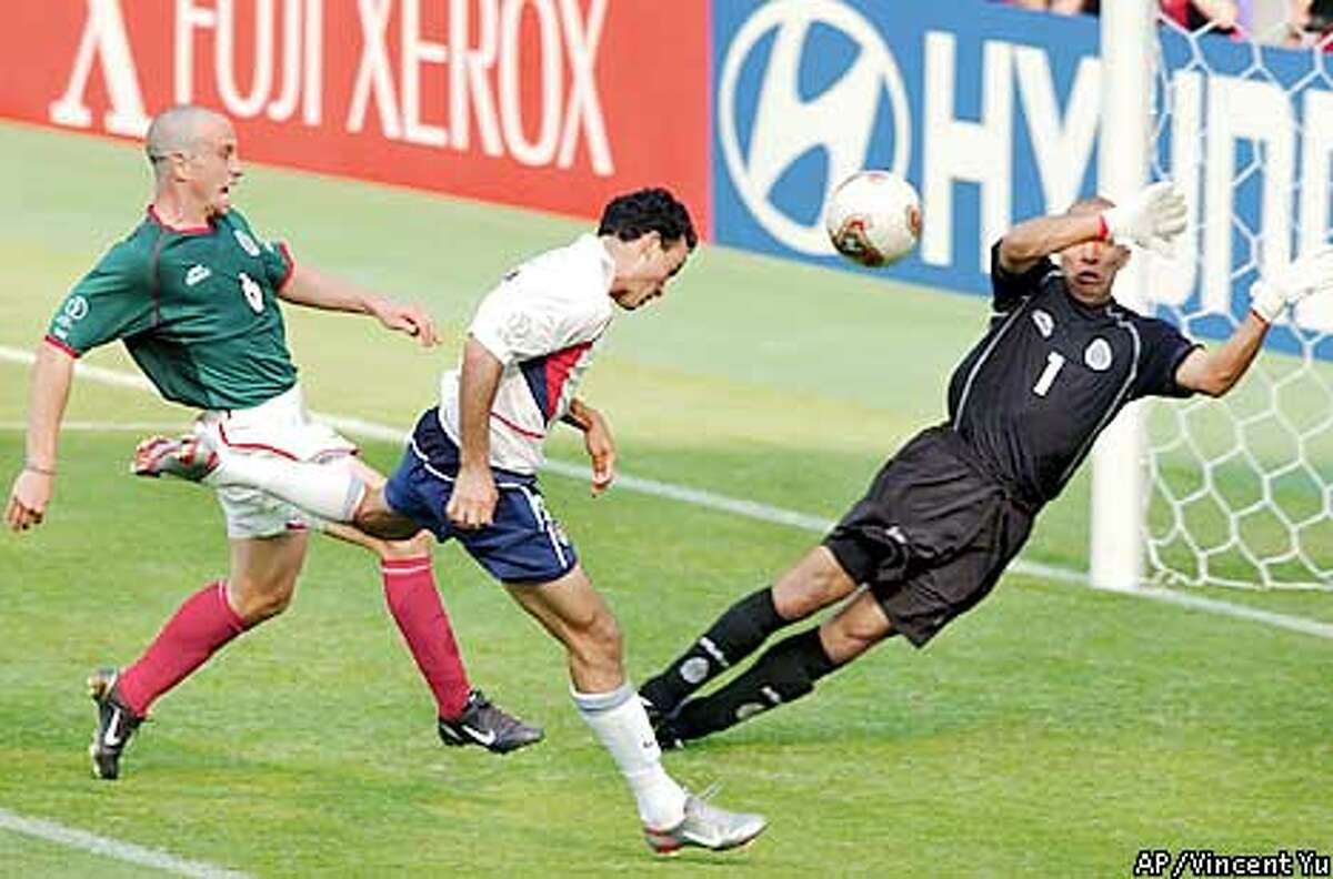 USA's Landon Donovan, center, heads the ball past Mexico's goalkeeper Oscar Perez, right, and Gerardo Torrado to score during their 2002 World Cup second round soccer game at the Jeonju World Cup stadium in Jeonju, South Korea, Monday June 17, 2002. (AP Photo/Vincent Yu)