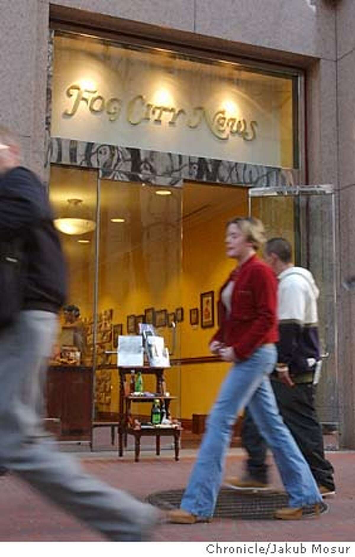 People walk in front of Fog City News, owned by Adam Smith, sells newspapers, magazines, and imported chocolate in the financial district in San Francisco on Thursday, Jan. 8, 2004. Event on 1/8/04 in San Francisco. JAKUB MOSUR / The Chronicle