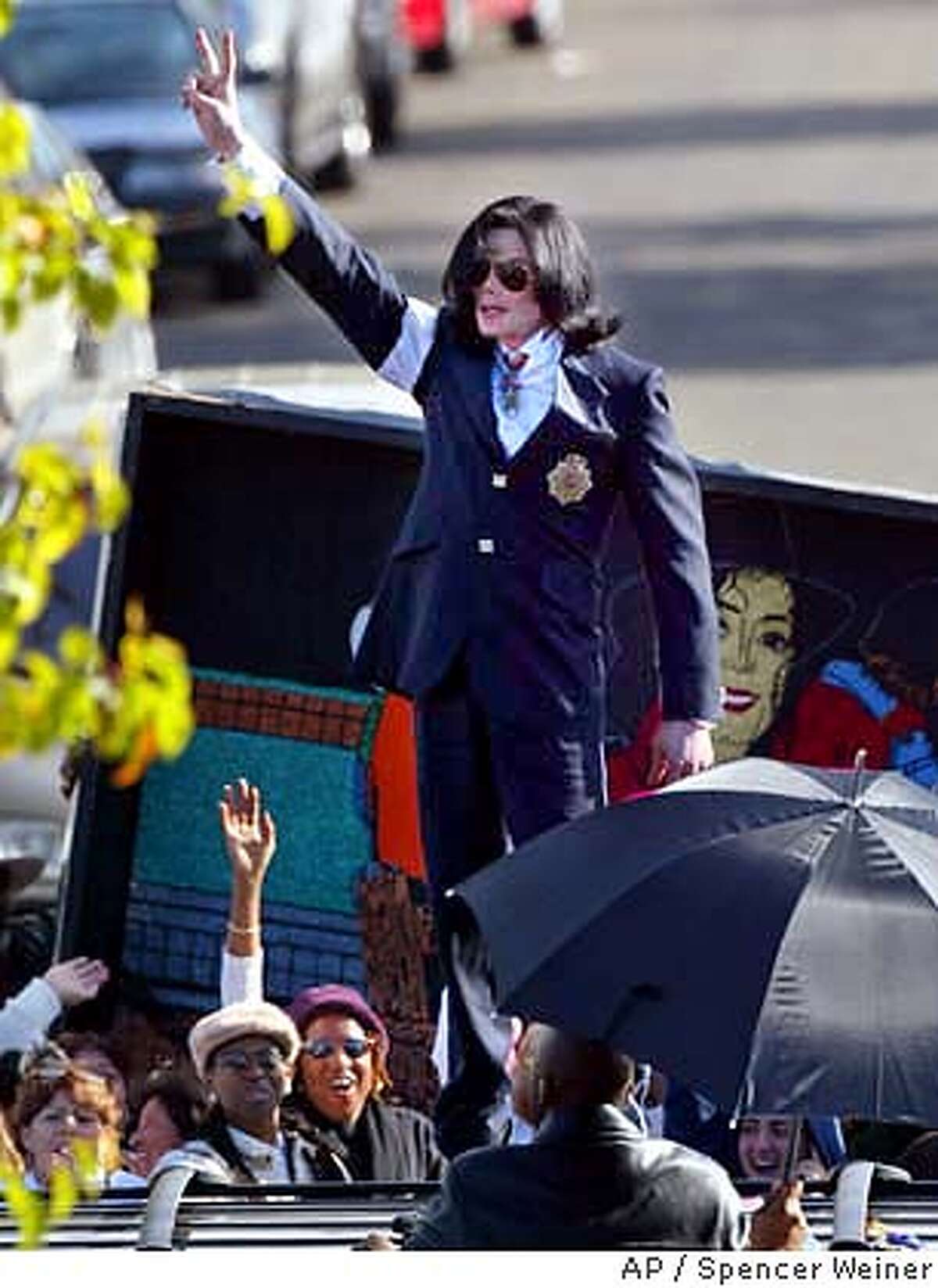 flashes the peace sign to his fans from on top of his limousine as he leaves the courthouse in Santa Maria, Calif., after his arraignment on child molestation charges Friday, Jan. 16, 2004. (AP Photo/Spencer Weiner, pool)