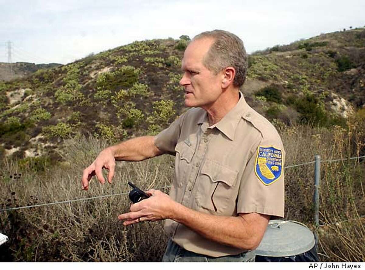Doug Updike, describes how a mountain lion attacks its prey near the entrance to a trail of the Whiting Ranch Wilderness Park in an unincorporated area of Orange County Friday, Jan. 9, 2004, following a pair of mountain lion attacks in the area. (AP Photo/John Hayes)