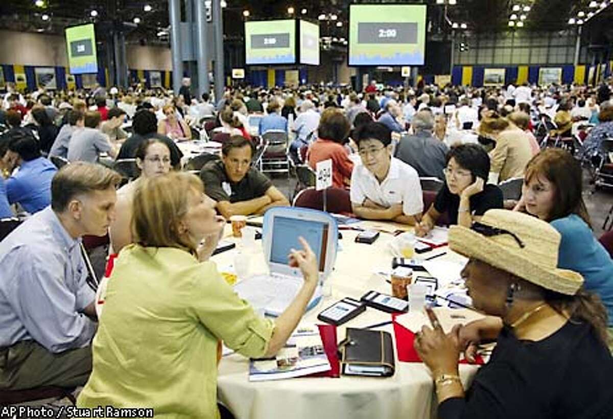 Participants of table no. 494 watch their facilitator Sharon Jones, foreground second from left, explain procedure at a historic 21st century town hall meeting to consider the World Trade Center site plans presented by the Lower Manhattan Development Corporation and the Port Authority of New York and New Jersey, July 20, 2002, in New York. Also to be discussed is the creation of a memorial to the victims of Sept 11 and other priorities for the rebuilding process in downtown New York. (AP Photo/ StuartRamson)