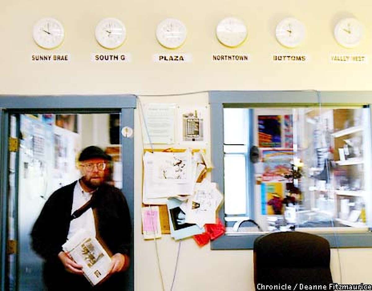 Kevin Hoover, editor and publisher of the Arcata Eye newspaper walks through the small newsroom. On the wall behind him is joke featuring six clocks, each showing a different neighborhood of the small town of Arcata as if in different time zones, but all showing the same time. Hoover is known for writing the police blotter in a very humorous and poetic style. CHRONICLE PHOTO BY DEANNE FITZMAURICE